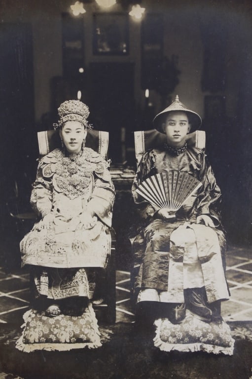QUNGUA: YOUNG MALAYSIAN COUPLE AT WEDDING: [x] Chin Photographers (Malacca). QUNGUA; TRADITIONAL CLOTHING. YOUNG MALYSIAN COUPLE AT WEDDING. Circa 1890s. Studio portrait. Silver print on decorative period mount in mat. Chin studio stamp with C