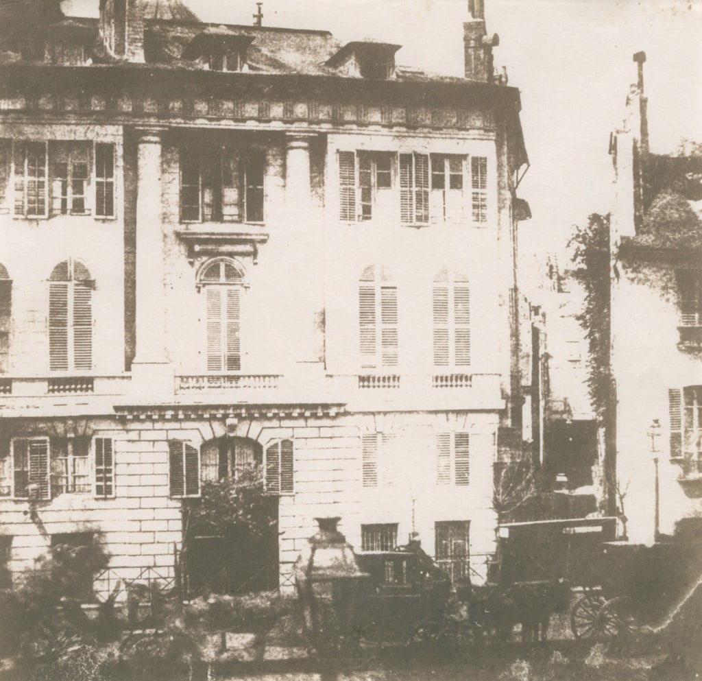 TALBOT, WILLIAM H.F. CARRIAGES, PARISIAN TOWNHOUSE: Talbot, William Henry Fox. CARRIAGES AND PARISIAN TOWNHOUSES. 1843. Unknown photographic process. Print has brown/reddish tone. In mat. Print: 16.5 x 17 cm; mat: 45.5 x 35.5 cm. Generally very good co