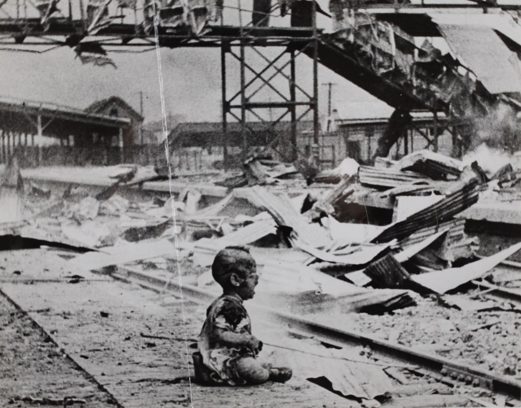 WONG, H.S. BLOODY SATURDAY. SHANGHAI, 1937: WONG, H.S. BLOODY SATURDAY. Shanghai, 1937. Ferrotyped silver print. Depicts Chinese baby among ruins of Shanghai South railway station, minutes after a Japanese air attack during the Second Sino-Japa