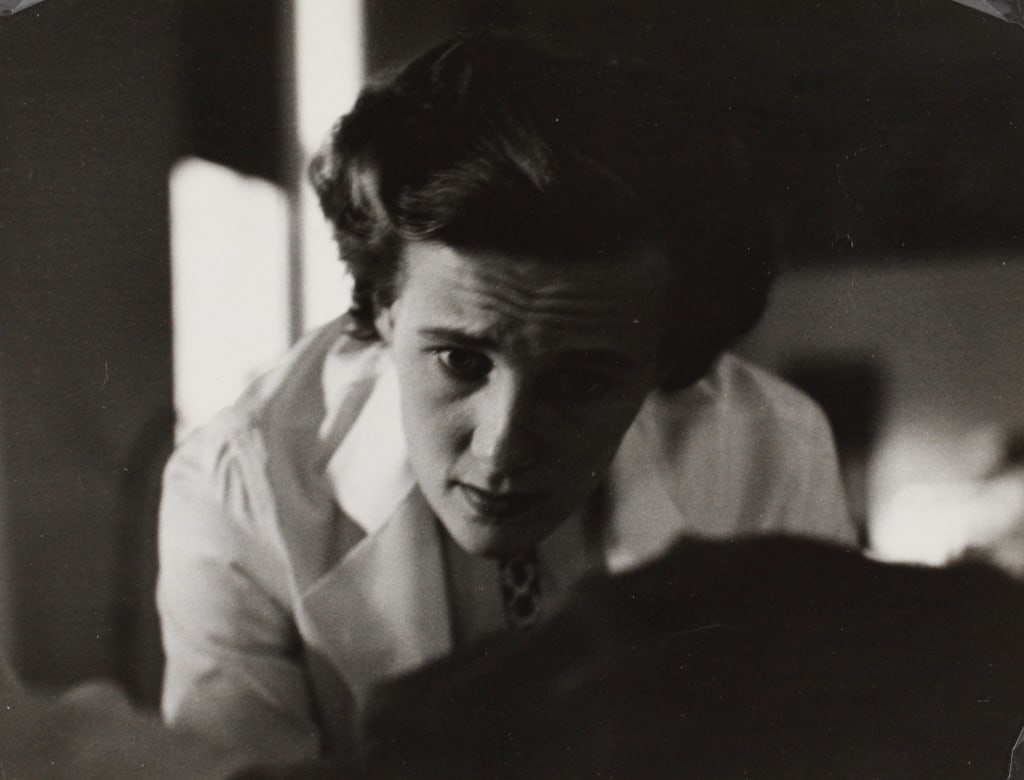 FEINGERSH, ED. WOMAN DOCTOR WITH A PATIENT. c.1940: FEINGERSH, Ed. DOCTOR WITH A PATIENT; for an article in McCall's magazine "A Day in the Life of a Woman Doctor." Circa 1940. Silver print mounted with plastic corners in mat. Print verso with Feingers