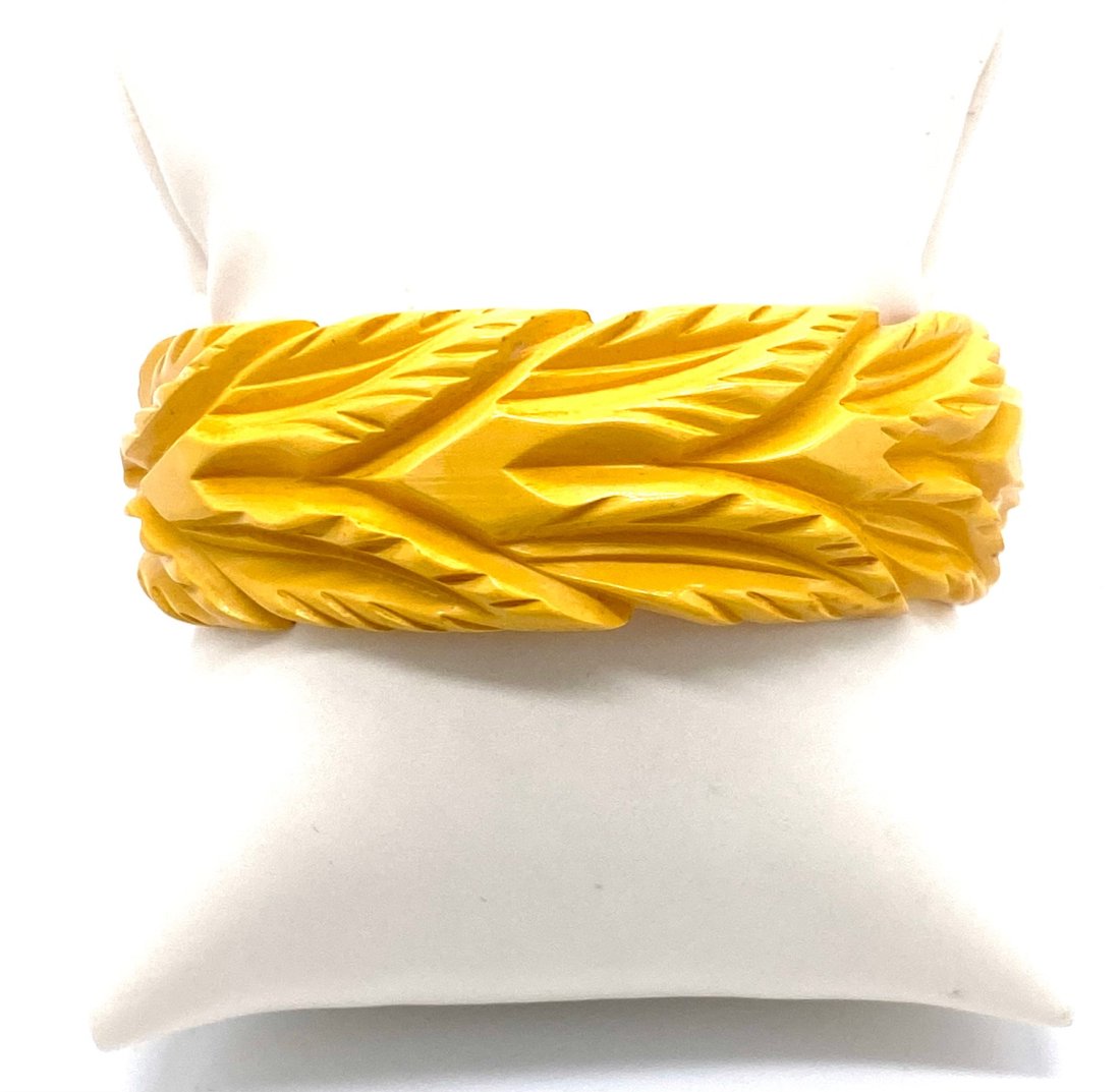 Bakelit Butter Yellow Carved Bangle: Bakelite Butter Yellow Carved Bangle. Beautiful carved. 1" wide. Good condition, no breaks or chips. Slight discoloration. See photos for detail. This sale is online only-no public preview or live in 