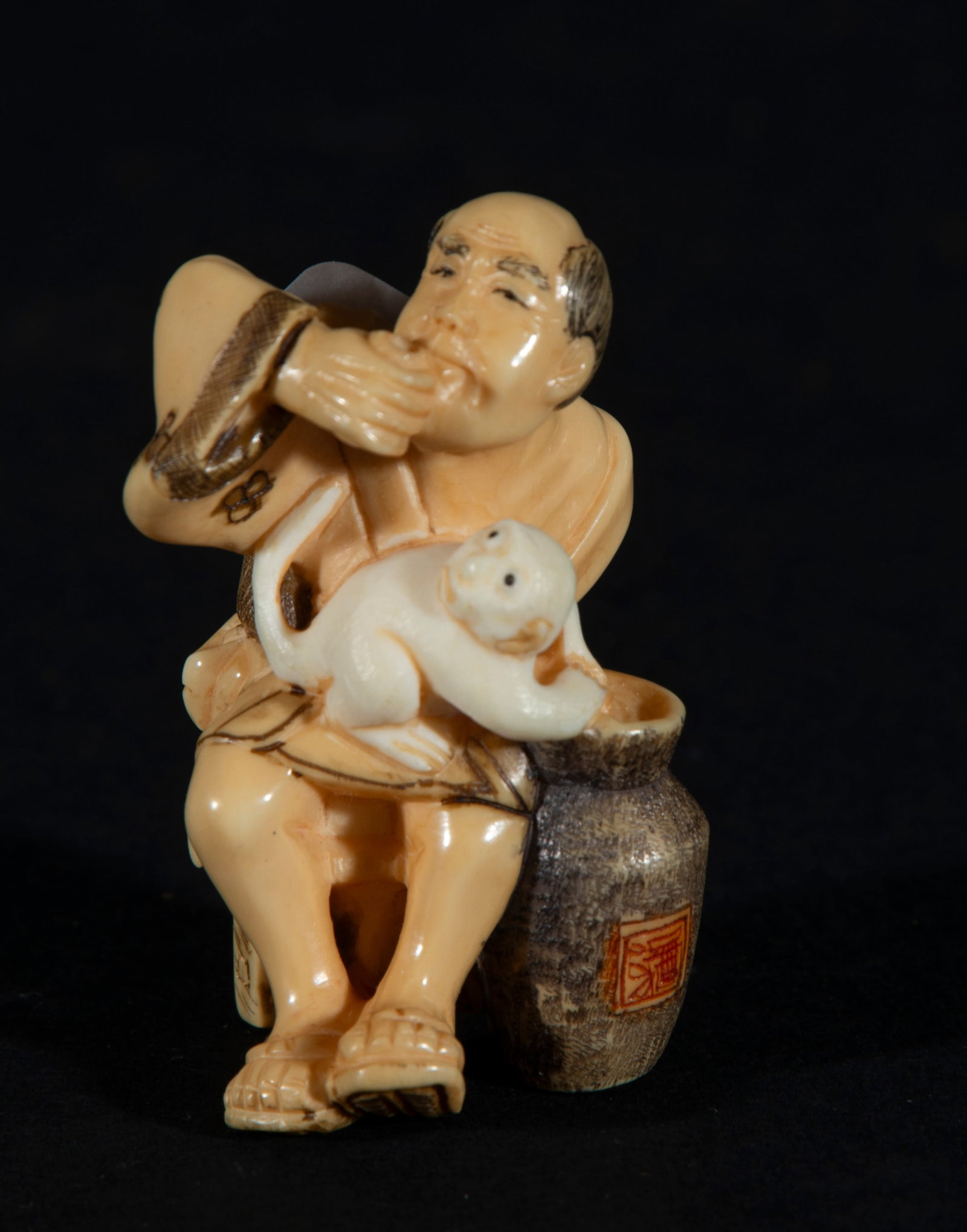 Japanese Netsuke on Mammoth Tusk (Mammuthus primigenius) depicting Old Man with Monkey, 19th century: With artisan seal, measurements: 4.5 x 3 x 2.5 cm. Provenance: private collection of a lawyer and collector, Barcelona. Acquired in the 60s-70s in Paris.