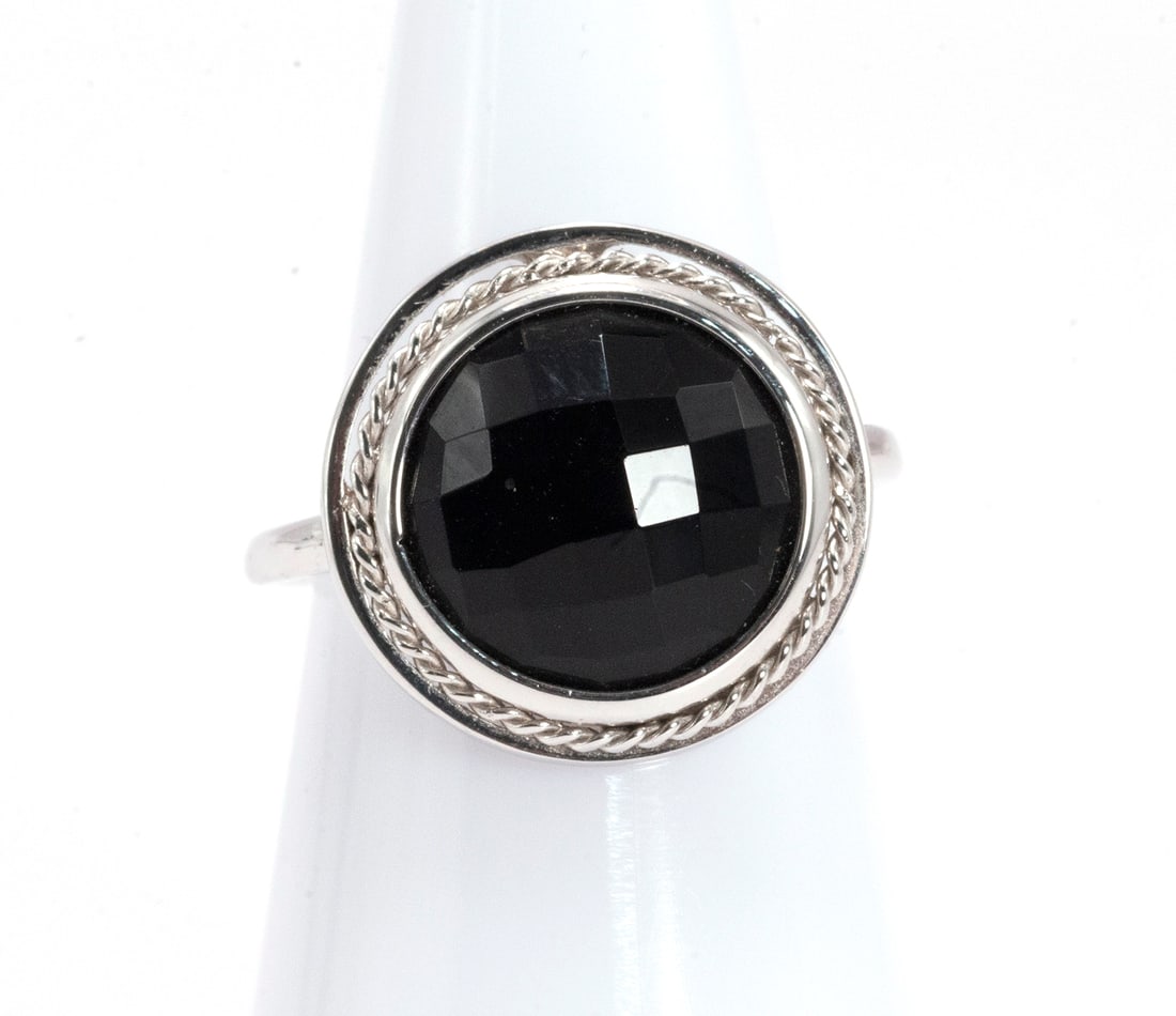Onyx rosette ring: Rosette model 18kt white gold ring, with faceted central onyx setting and braided detail. Size: 13 (53). Weight 4.2grs