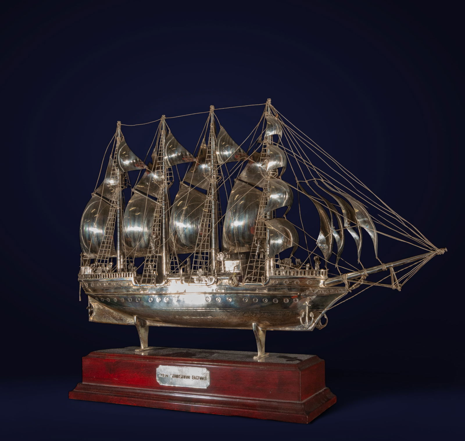 20th century Silver Ship Model: This silver ship model is a detailed and precise work, representing a sailboat with all its sails spread. The technique used includes goldsmith work to create minute details in the structure of the bo