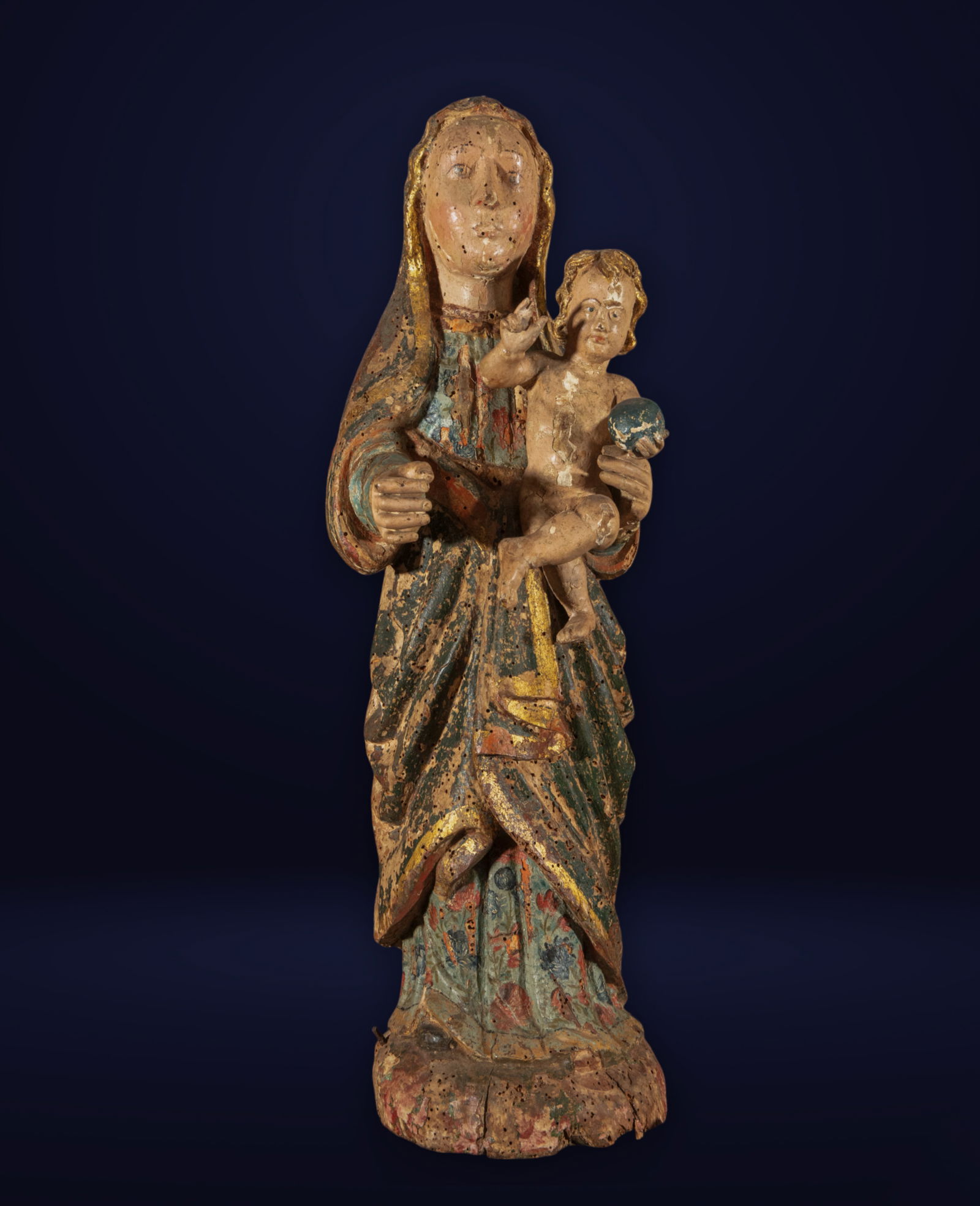 Spanish School of the 16th Century - Virgin and Child: Carved in wood and covered with polychrome. Dimensions 61 × 24 × 17 cm. This work captures a maternal image of the Virgin holding the Infant Jesus, who in turn holds a small orb in his left hand, a