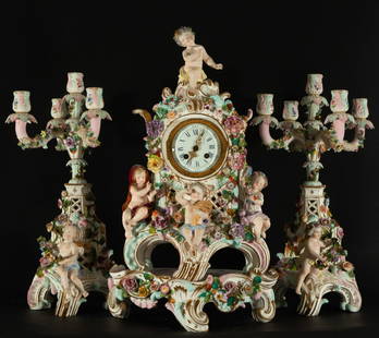 Clock trim and Candelabra in Meissen porcelain with Cherub motifs, 19th century: Clock measures: 48 x 28 x 15 cm, candlestick measures: 57 x 33 x 18 cm