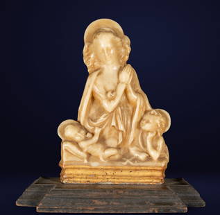 Praying Virgin. Andalusian School. 18th Century: Polychrome wax on a gilded wooden base. The image shows the Virgin Mary in a prayerful attitude, accompanied by two child angels standing reverently on either side. The main figure, with an oval face