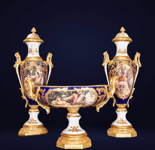 Set of vases and centerpiece in French Sevres porcelain. 20th century.: Porcelain and gilt bronze. Ornamental set in the Sèvres style, comprising a pair of lidded vases with a centerpiece. All three pieces feature rich decoration in cobalt blue enamel and gold appliqués