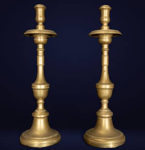 Pair of liturgical candlesticks. European School. 18th century.: Gilt bronze. A set of tall, segmented, church liturgical candelabras, each composed of a stepped bell-shaped base, a truncated cone-shaped shaft with moldings, and a wide ring used to collect wax. The