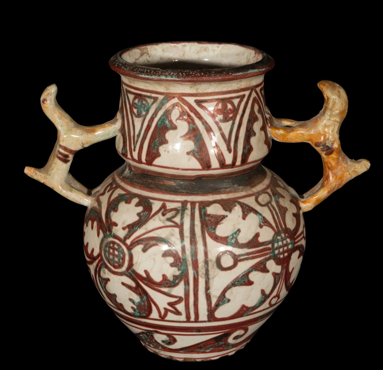 Small Amphora with Metallic Reflections, 19th Century: Glazed ceramic with metallic reflections. Dimensions: 23 x 26 x 16 cm. Small amphora decorated with geometric and floral motifs in reddish, ochre, and greenish tones, with zoomorphic handles in the sh