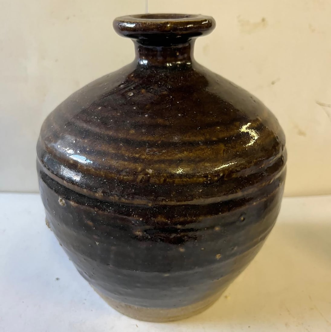 Bottle with a large, globular body and flared neck, made of thick stoneware with a monochrome black (1 of 10)
