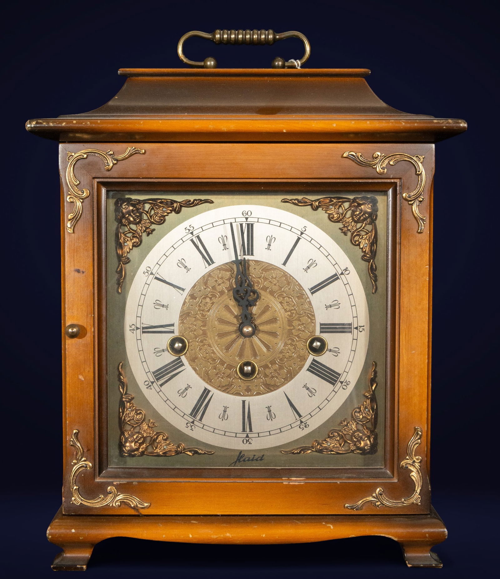 Kieninger mantel clock. German School. 20th century.: Varnished wooden mantel clock with gilt bronze mounts and a circular metal dial with Roman numerals. Measures 31 x 24 x 15 cm. The design, clearly inspired by Neoclassicism, combines the technical pre