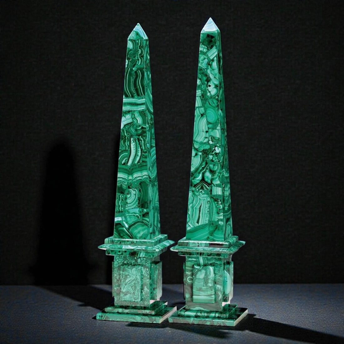 Pair of Obelisks. Russian School. 20th Century: Carved and polished malachite. Approximate height: 40 cm each. Elegant pair of decorative obelisks crafted in malachite, a semi-precious stone known for its intense green hue and distinctive veining,
