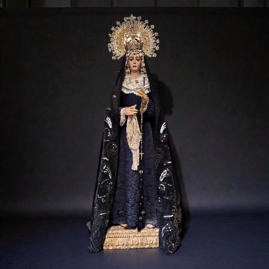 Dressed Mater Dolorosa with Silver Crown. Spanish School. 19th Century: Carved and polychromed wood, textiles, lace, and silver. Dimensions: 100 cm height (sculpted), 133 cm total with base and crown, 36 cm wide, crown 22 x 31 cm, base 9 cm. Magnificent dressed sculpture