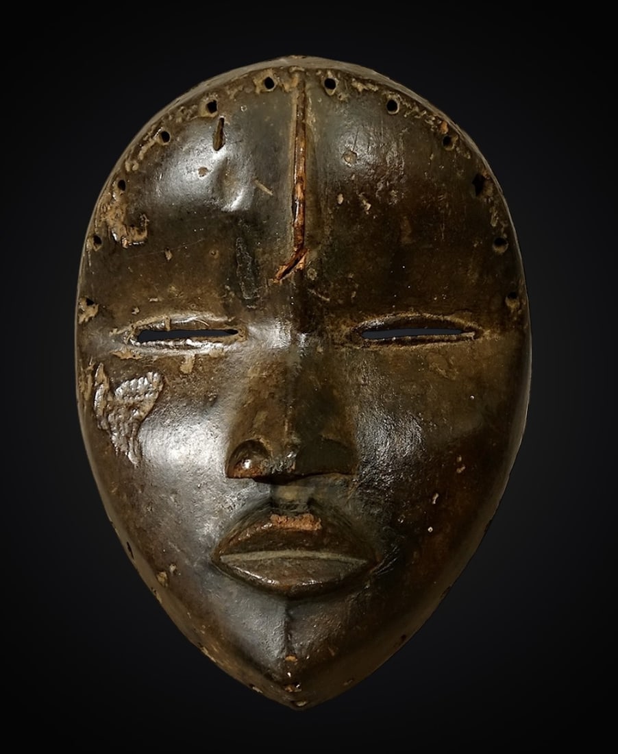 “Tankagle?? dance mask, Ivory Coast, Dan ethnic group, late 19th century: Carved wood. Dan dance mask known as a tankagle, of remarkable sculptural quality. It is most likely a female mask, as indicated by the almond-shaped, slanted eyes and the sensual, carefully modeled l