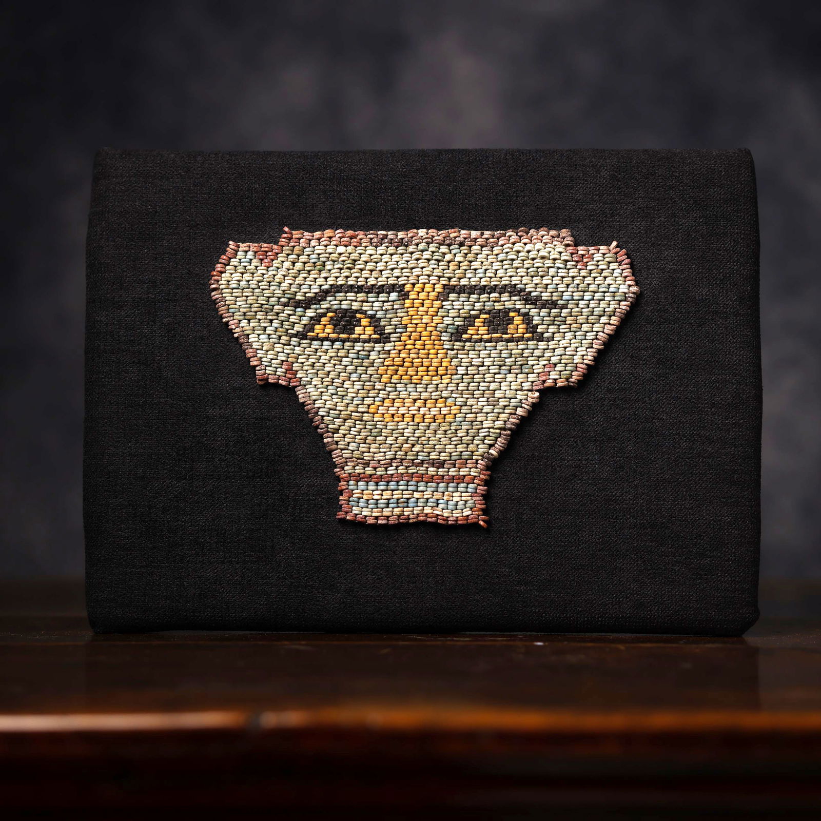 Rare Egyptian mummy mask in faience beads, Ptolemaic Period (332 - 30 BC): 13.5 x 19.5 x 0.5 cm (mask), Support: 22 x 31 x 2 cm, in polychrome faience beads.