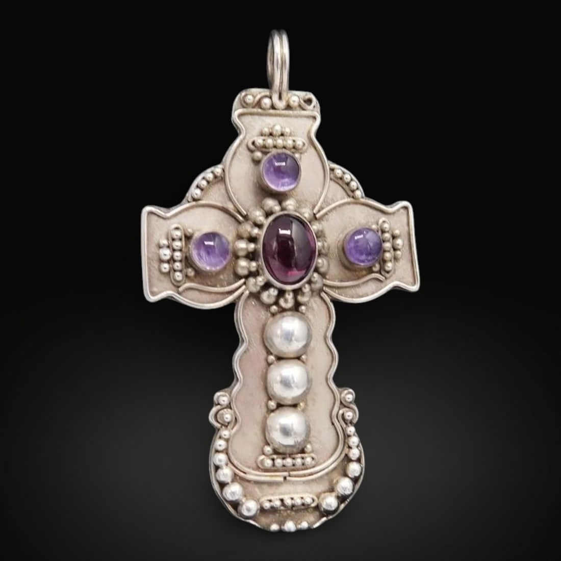 Silver pendant cross with garnet and amethysts, 20th century: Sterling silver (925), crafted using traditional goldsmithing techniques with relief work and stone setting. Measures 5.5 x 3.0 cm; weight 8.3 g. This large, elegantly sized pendant cross is structure