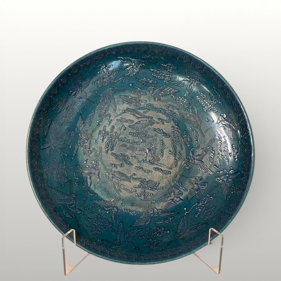 Plate with cranes and clouds, China, Qing Dynasty, 19th Century: Large-format porcelain, 34 cm in diameter. Decorated with cranes in flight among stylized clouds (tsi), arranged in a circular composition. The rim is ornamented with a frieze of mushrooms symbolizing