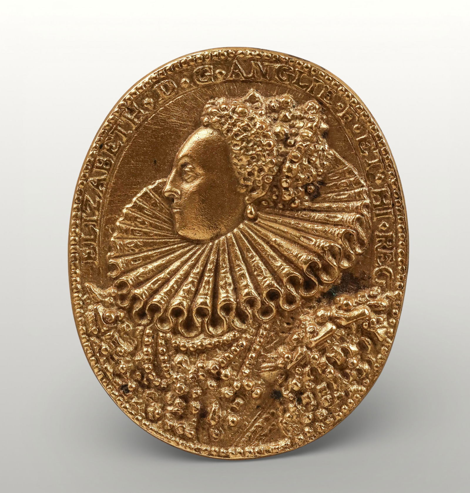 Medallion with portrait of Elizabeth I of England, Signed, European Historicist School, 19th Century: Gilded bronze in relief. Measures 5 x 4 cm. Oval medallion featuring a profile bust of Elizabeth I of England, her face turned to the left and framed by an elaborate ruff with wide radial folds that l