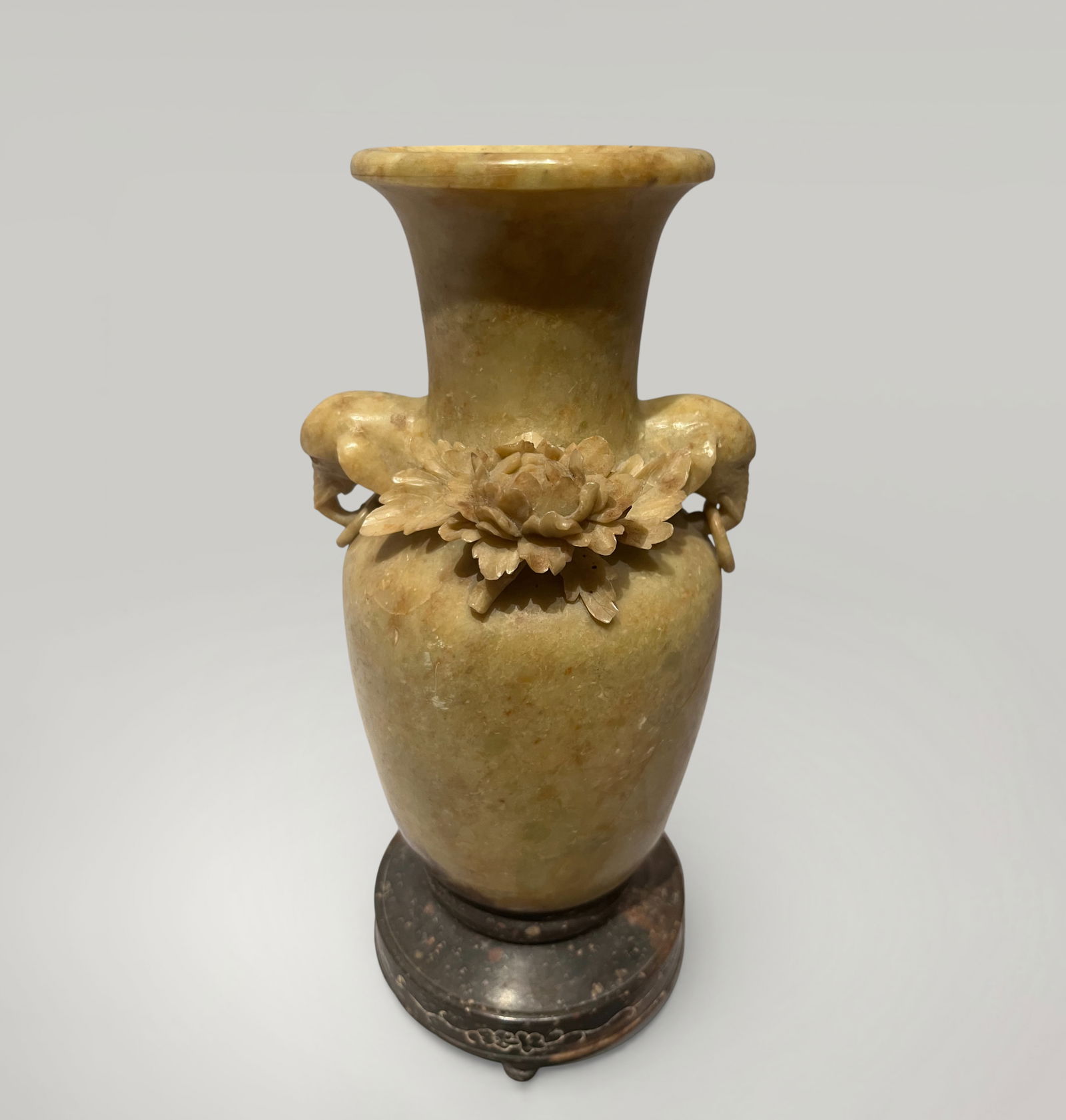 Baluster vase with peonies and handles with elephant heads, Chinese production, Qing Dynasty, 19th: Soft soapstone, sculpted in high relief. Measures 18 x 6 cm. Finely chiseled baluster vase, ornamented on the shoulder with two open peonies in strong relief, accompanied by a pair of zoomorphic handl