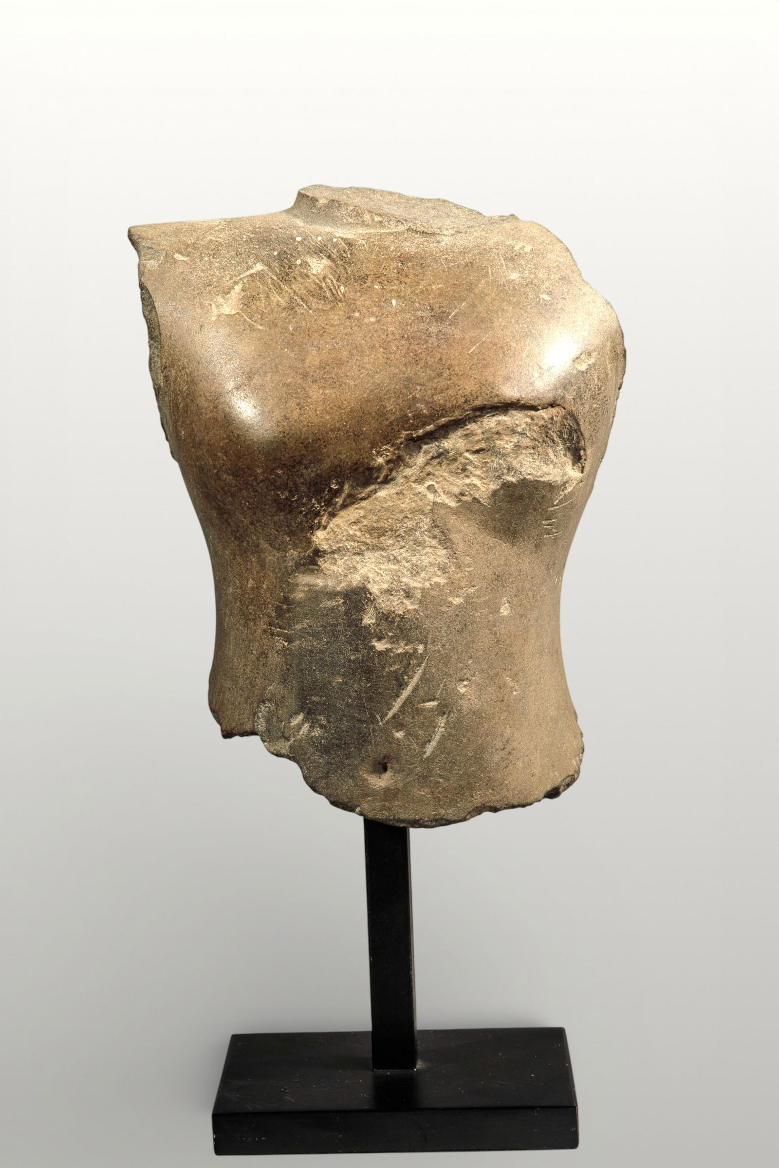 Fragment of male torso, Khmer art, Angkor period, 12th - 13th century: Sculpted stone. Sculptural fragment representing the upper part of a male torso, rendered with powerful and synthetic modeling. The pectorals are broadly rounded, and the transition to the shoulders a