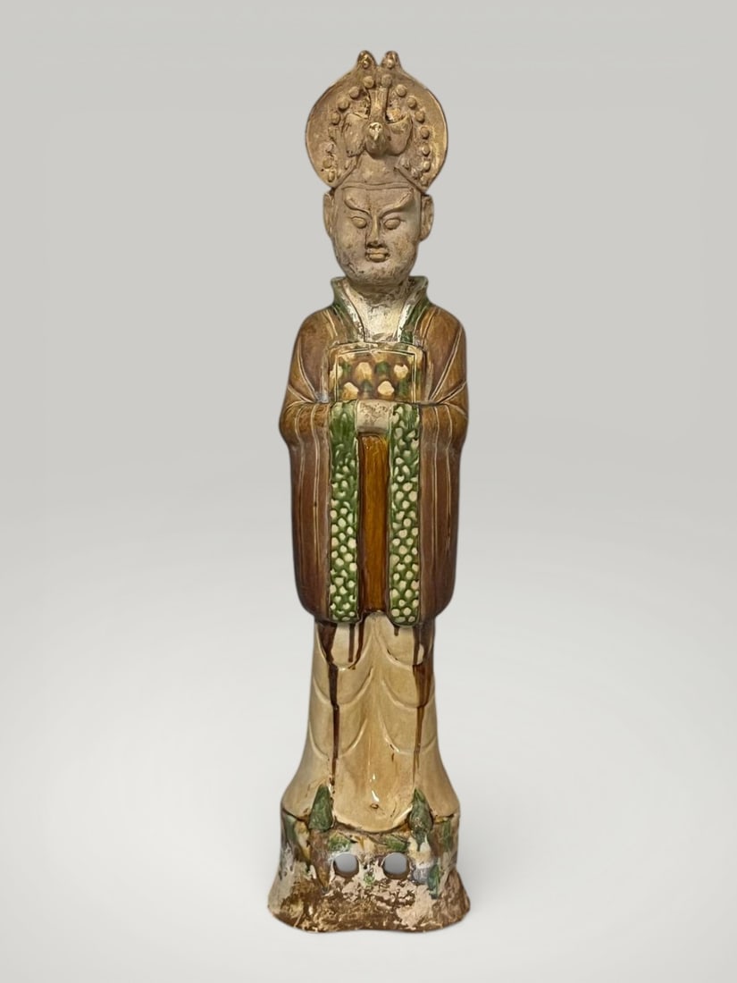Dignitary of the Tang court, sancai sculpture, 7th - 9th century: Terracotta sculpture with sancai glazes. Dimensions not specified. Figure of a high-ranking dignitary depicted standing, with hands clasped over the chest in a ceremonial gesture, clad in a long robe