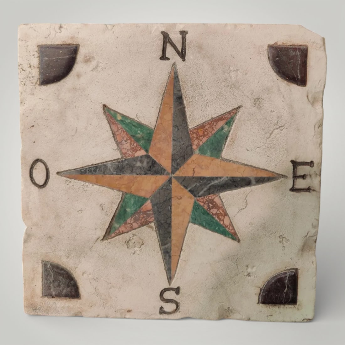 Marble tile with compass rose in polychrome marbles, Italy, 20th century: Carved and inlaid marble. Dimensions: 33 × 33 × 6 cm. A rare and decorative marble tile, centered by a compass rose executed in polychrome marble, with the cardinal points correctly positioned. A pi