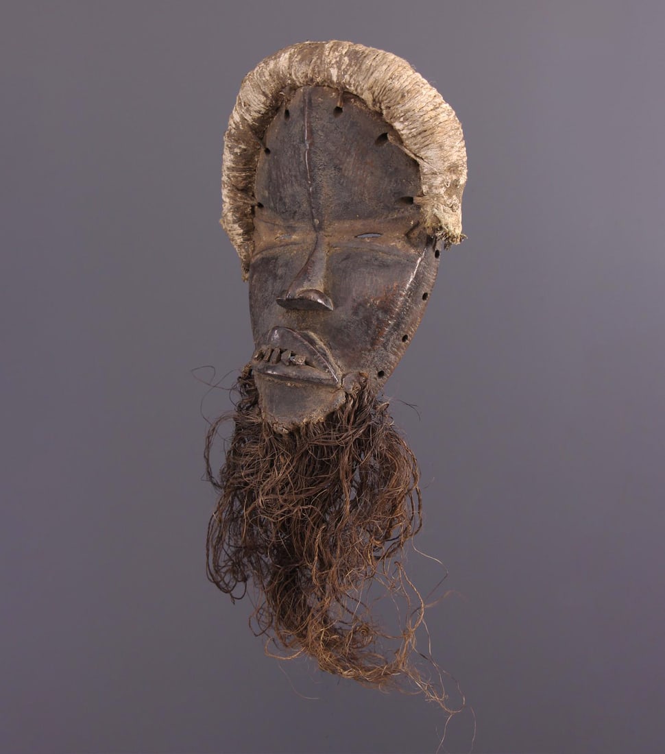 Tankaglé mask. Dan village, Ivory Coast. Mid-20th century: Carved wood with textile and raffia appliqués. Dimensions: 30 × 19 cm; weight: 0.50 kg. African Dan mask of the Tankaglé type, formally similar to the famous Déanglé model, conceived as an ideali