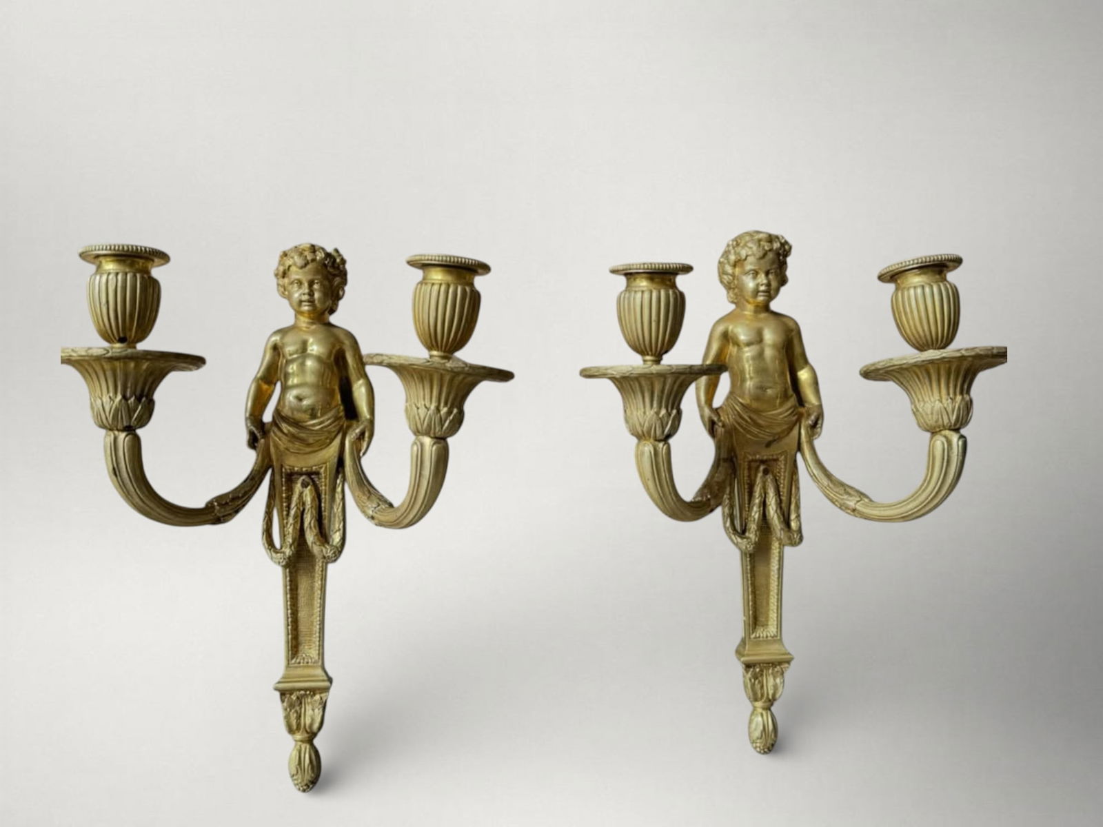 Pair of Louis XVI style wall sconces, based on a design by Jean-Louis Prieur, late 19th century: Gilt bronze. Dimensions: 33 x 33 cm. Pair of high-quality wall sconces, France, late 19th century, made following 18th-century models. The support is in finely chased and gilt bronze, executed accordi