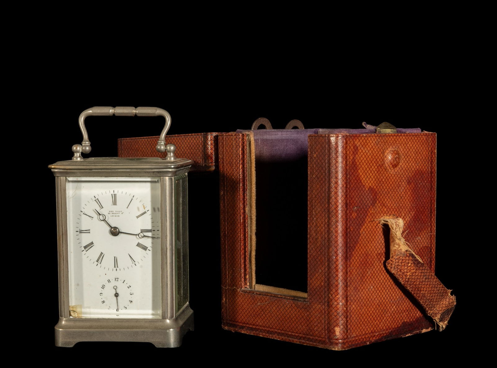 Elegant 19th-century English travel clock with alarm: Silver-plated bronze, with key, box dimensions: 16 x 10 x 10 cm. Clock dimensions: 11 x 8 cm
