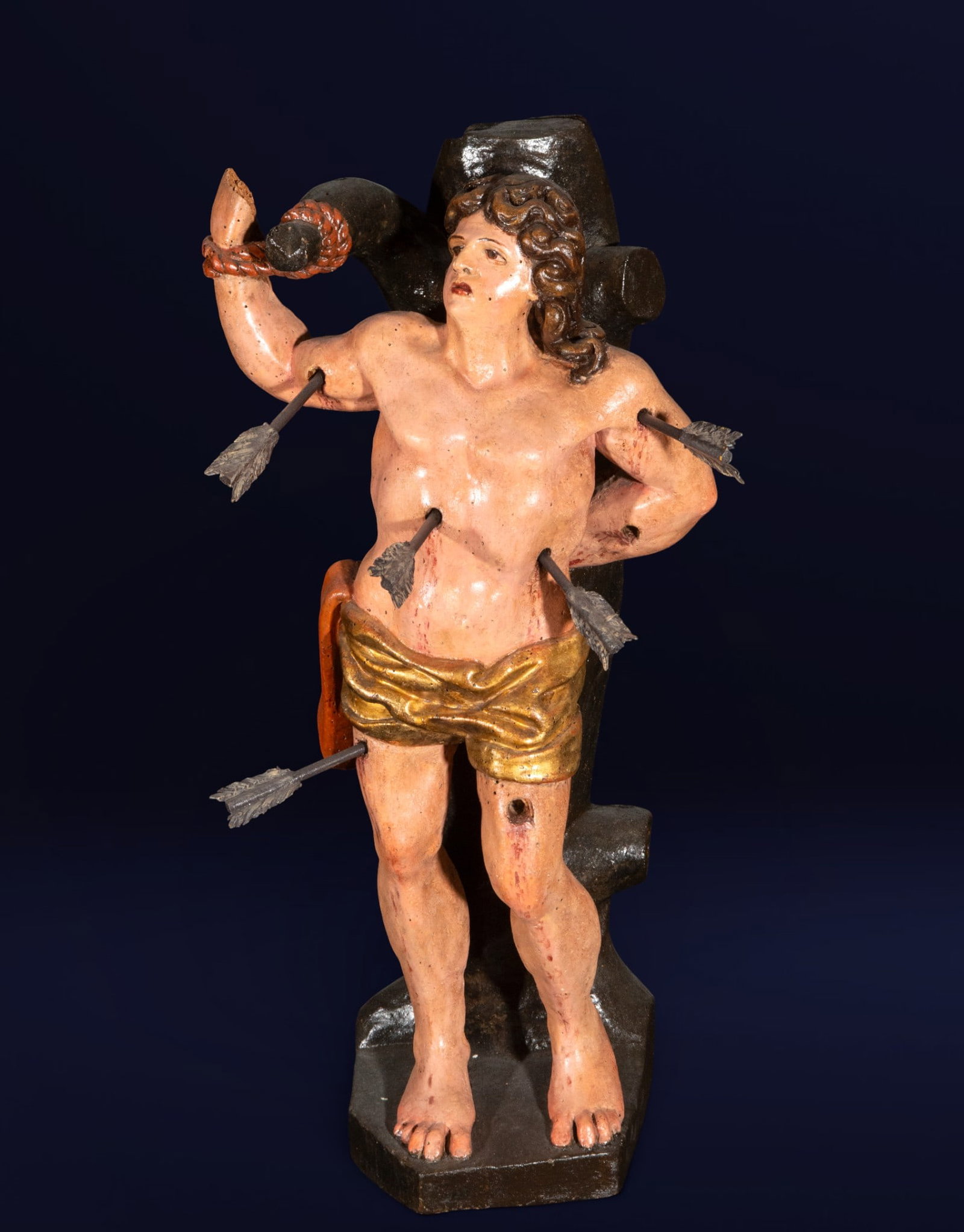 San Sebastián. Navarrese School of Juan de Anchieta or Ancheta, 16th Century.: Carved and polychromed wood. Measures 64 cm x 32 cm x 25 cm. This sculpture in the round depicts Saint Sebastian tied to a tree trunk, his naked body barely covered by a golden loincloth, pierced by a