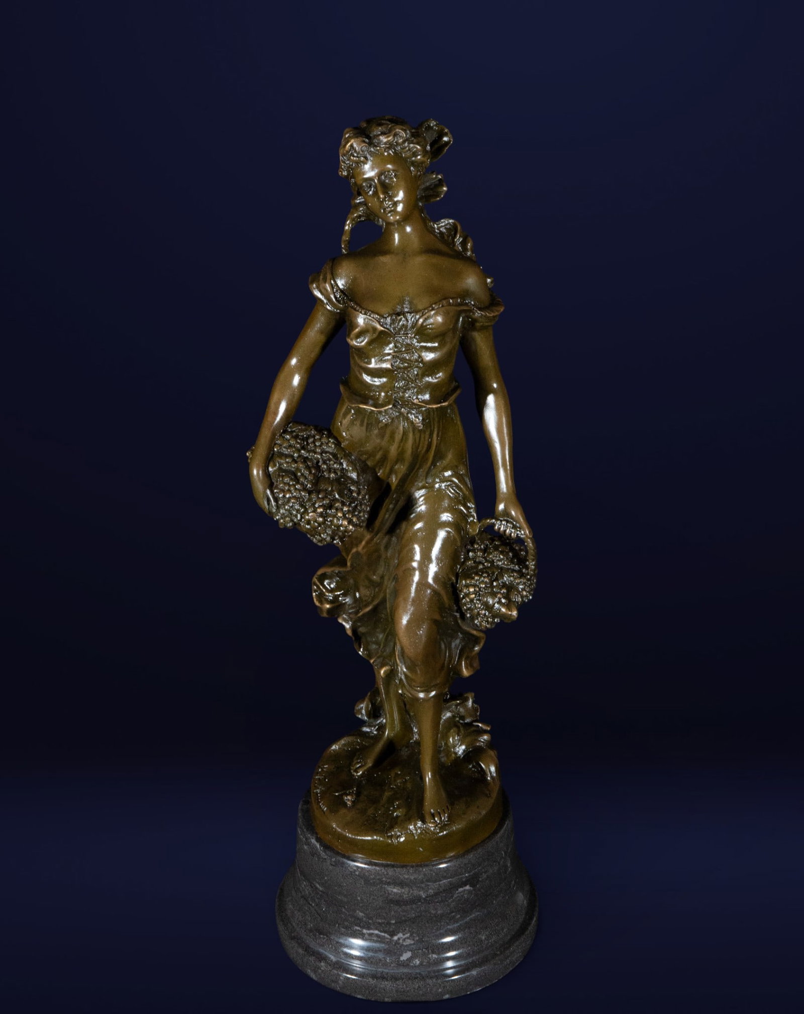 F. Moreau, Large Bronze of the 19th-20th century, signed: Patinated bronze. Measures 50 x 18 x 15 cm. Sculpture of a female figure in an everyday pose, carrying a basket of grapes. The body and drapery are rendered with a naturalistic style, achieved through