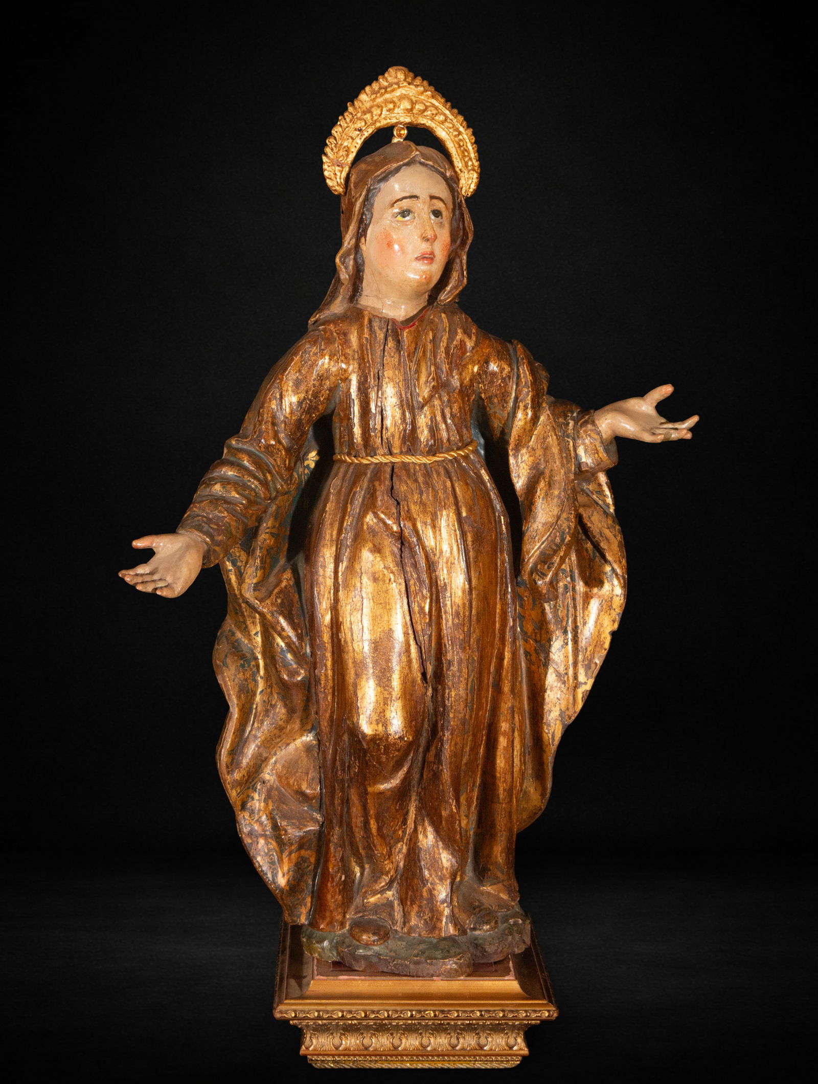 Saint Anne. 16th Century: Polychrome wood carving. Measures 82 x 54 x 21 cm. The figure is depicted frontally with open arms in a welcoming gesture, emphasizing the solemn verticality of the composition. The face displays stro