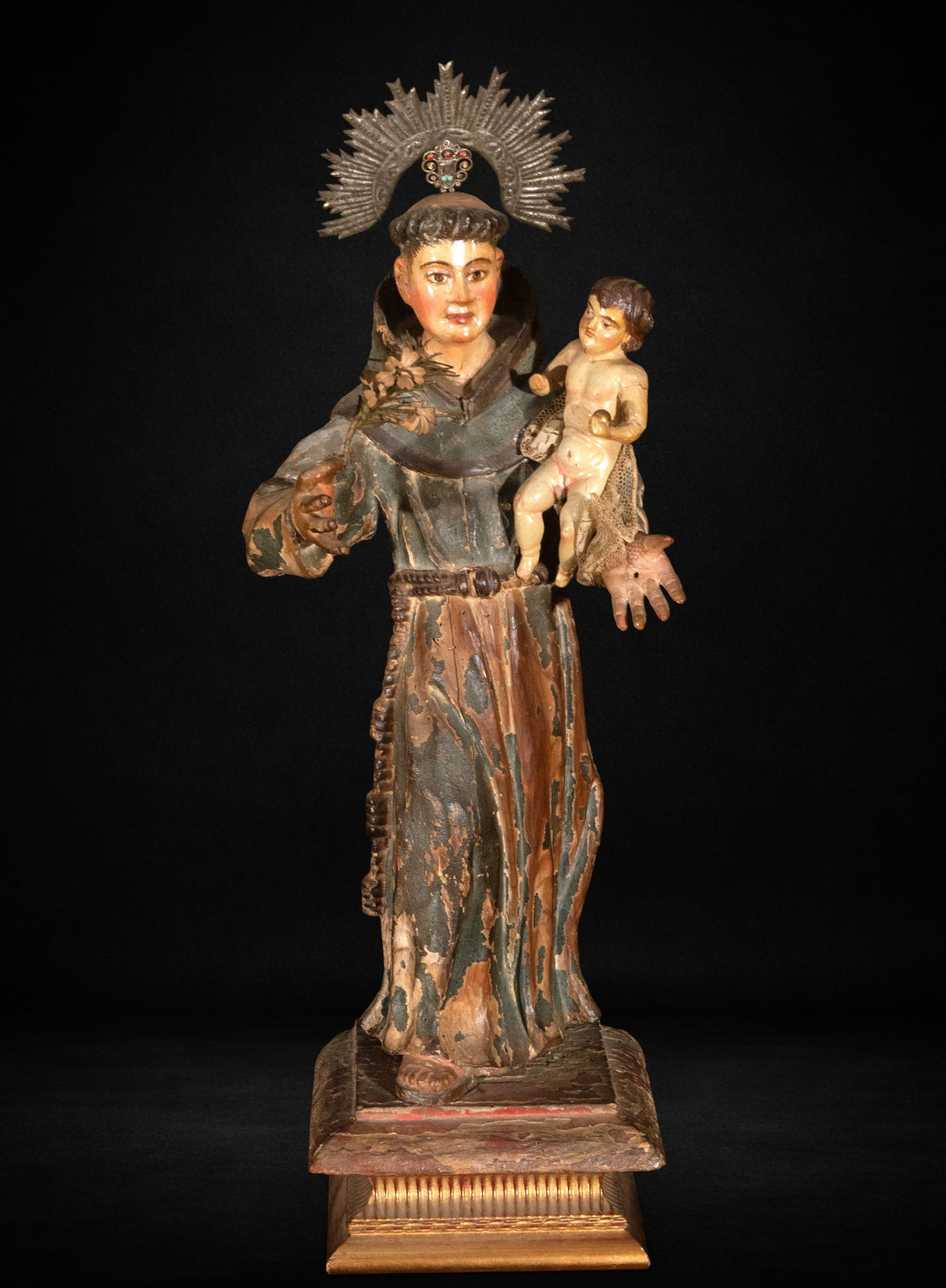 Saint Anthony with Child, 17th Century: Carved and polychromed wood. Measures 56 x 21 x 19 cm. Image of Saint Anthony carrying the Child on his left arm, wearing a Franciscan habit cinched with a cord. The original polychromy remains, thoug