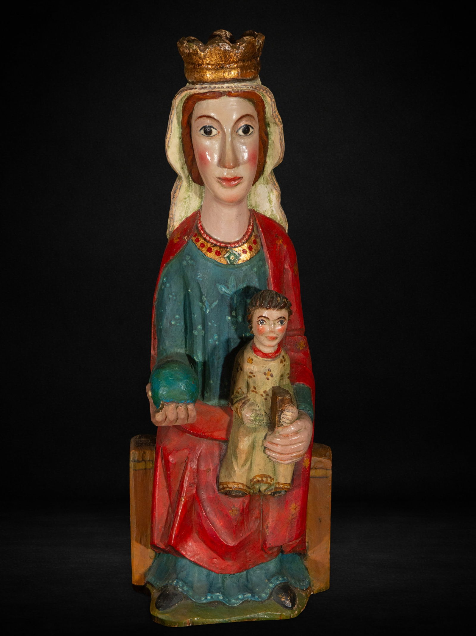 Seated Virgin, Neo-Romanesque style, First half of the 20th century: Carved and polychromed wood. Measures 50 x 20 x 13 cm. Seated Virgin in the Neo-Romanesque style with the Child facing forward. She holds a sphere in her hand while supporting the Child in a hieratic