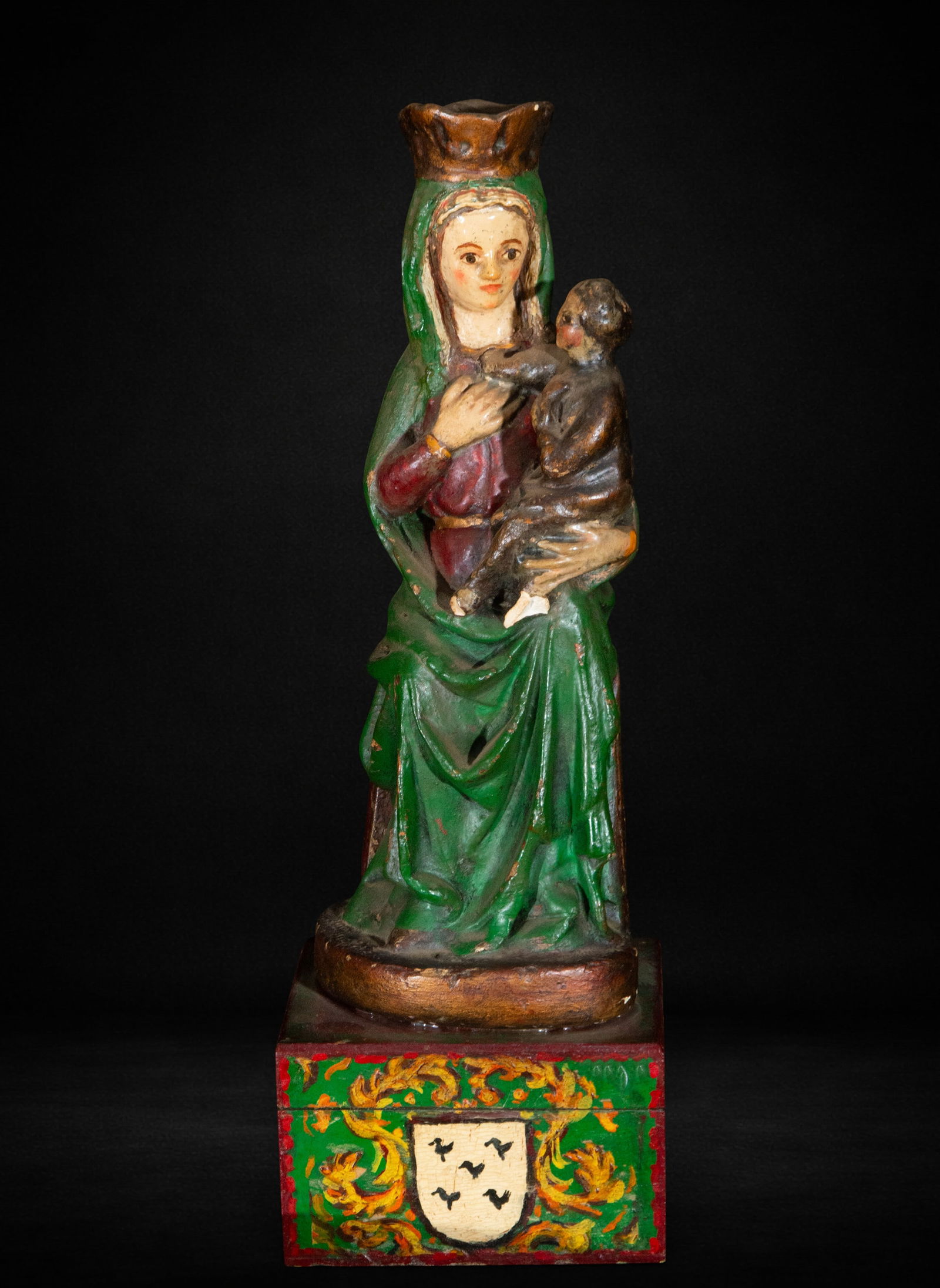 Neo-Gothic Virgin, First half of the 20th century: Carved and polychromed wood. Measures 31 x 10 x 9 cm. Neo-Gothic Virgin standing with the Child in her arms. Vertical composition with stylized folds, wearing a green mantle over a red tunic. Made in