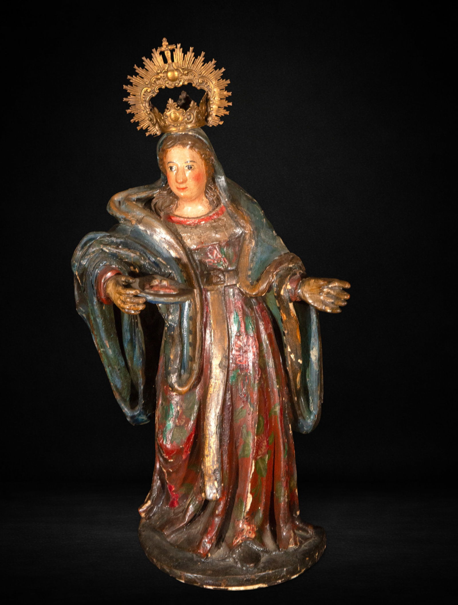 Saint Lucy, 17th Century: Carved and polychromed wood. Measures 50 x 26 x 14 cm. Saint Lucy carrying an attribute on a tray, devotional composition from the 17th century.