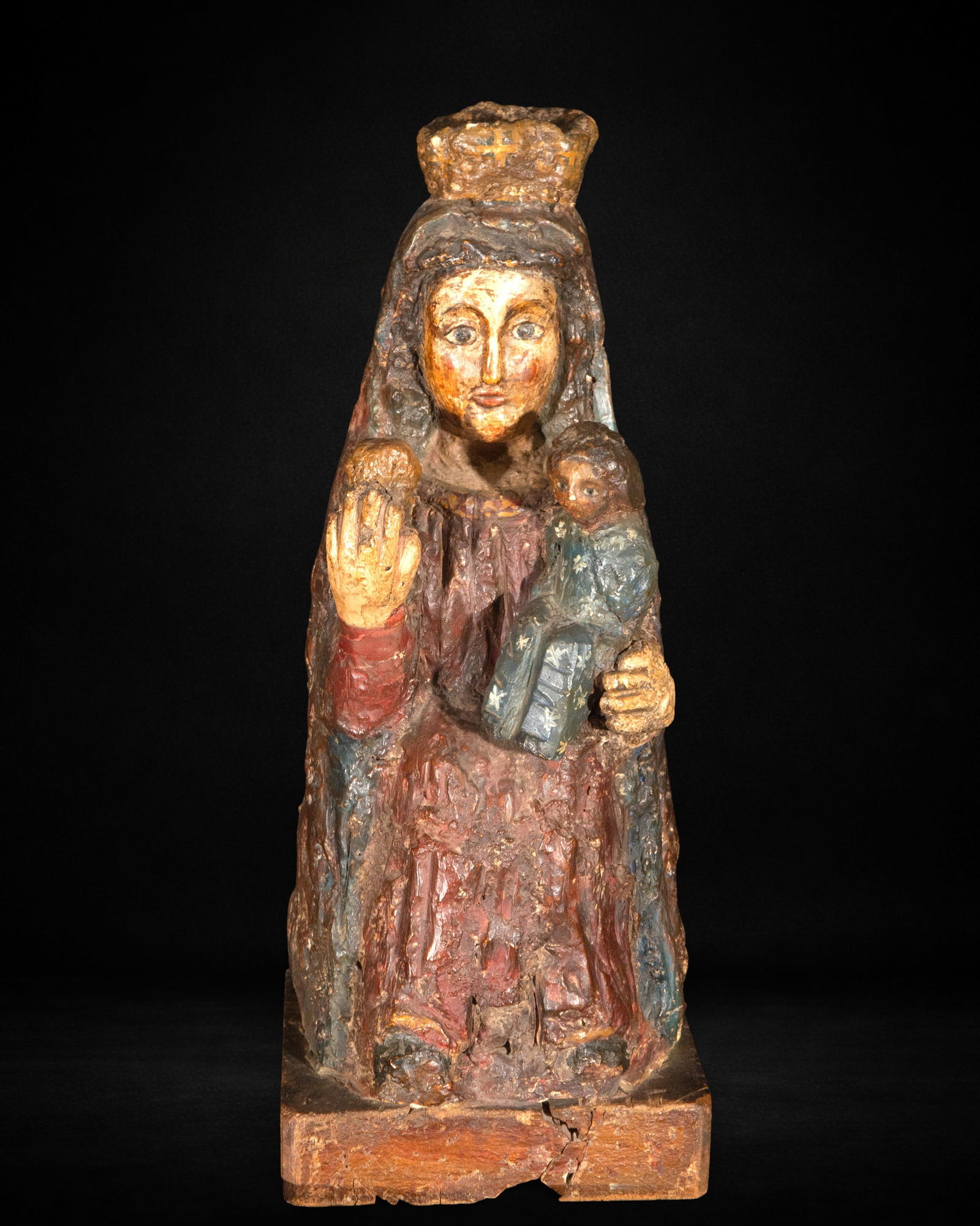 Pastoral wood carving, 20th century: Carved and polychromed wood. Measures 50 x 20 x 19 cm. Image of the Virgin with the Child seated, holding fruit in her right hand while the Child rests on her left arm; compact forms and simple modeli
