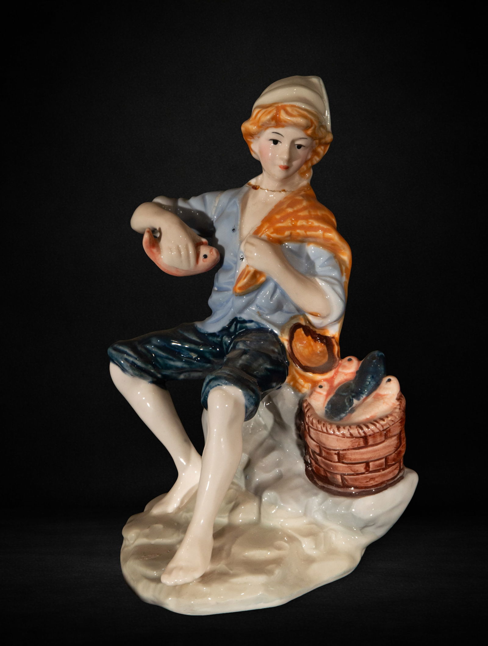 Porcelain figurine of a character resting (1 of 3)