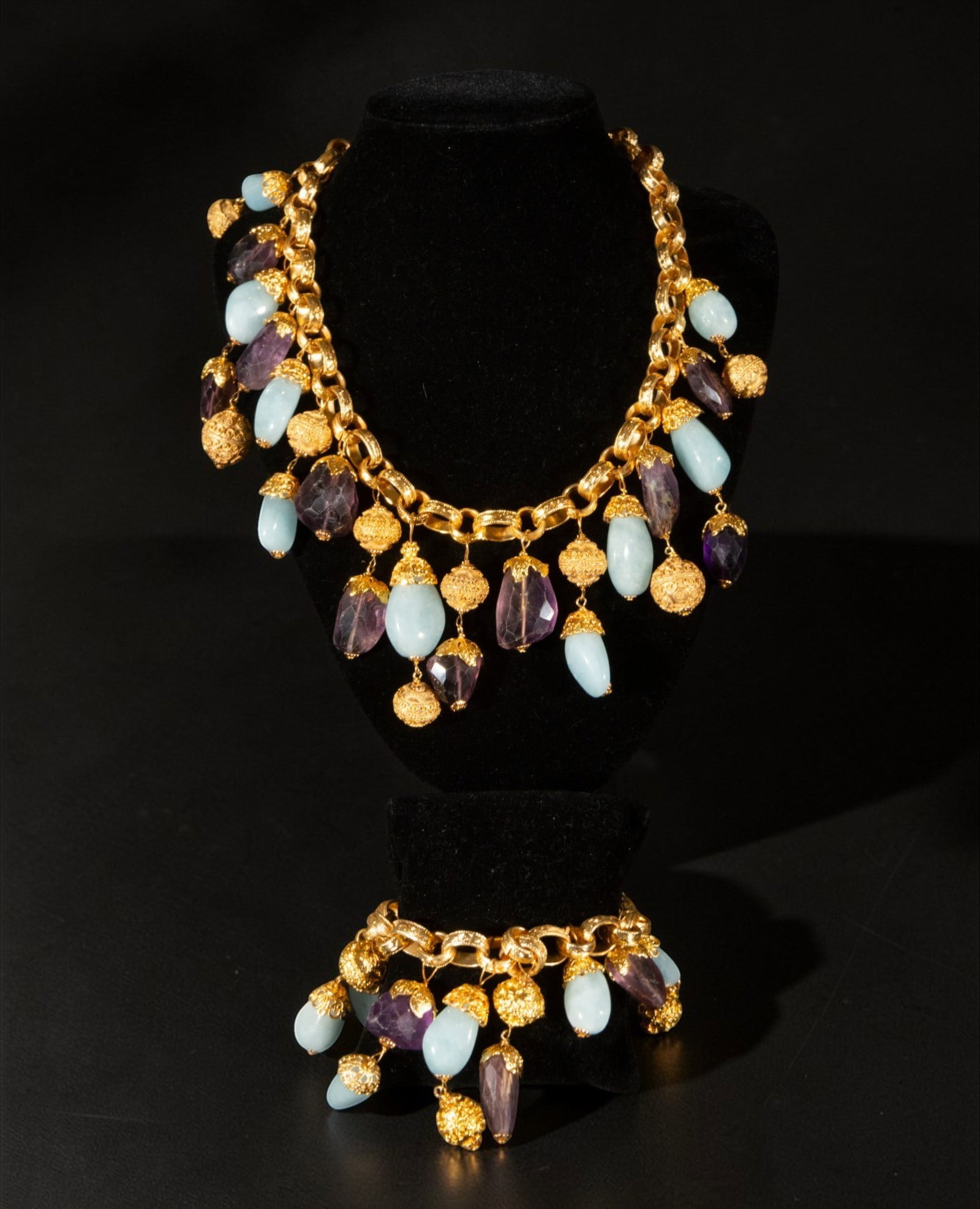 Gold-plated silver bracelet with charms and chalcedony: Gold-plated silver bracelet with charms and chalcedony. It features large links from which dangle chalcedony charms in shades of blue and green, accompanied by small, textured gold elements. The desig