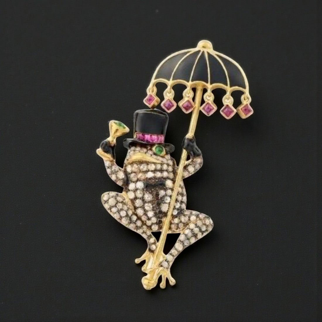 Enamel brooch in the shape of a frog with an umbrella, rubies, emeralds and diamonds: A figurative enameled brooch, crafted in silver with gilt plating, depicting a frog holding an umbrella. The surface is set with approximately 124 rose-cut diamonds weighing nearly 2 carats in total,
