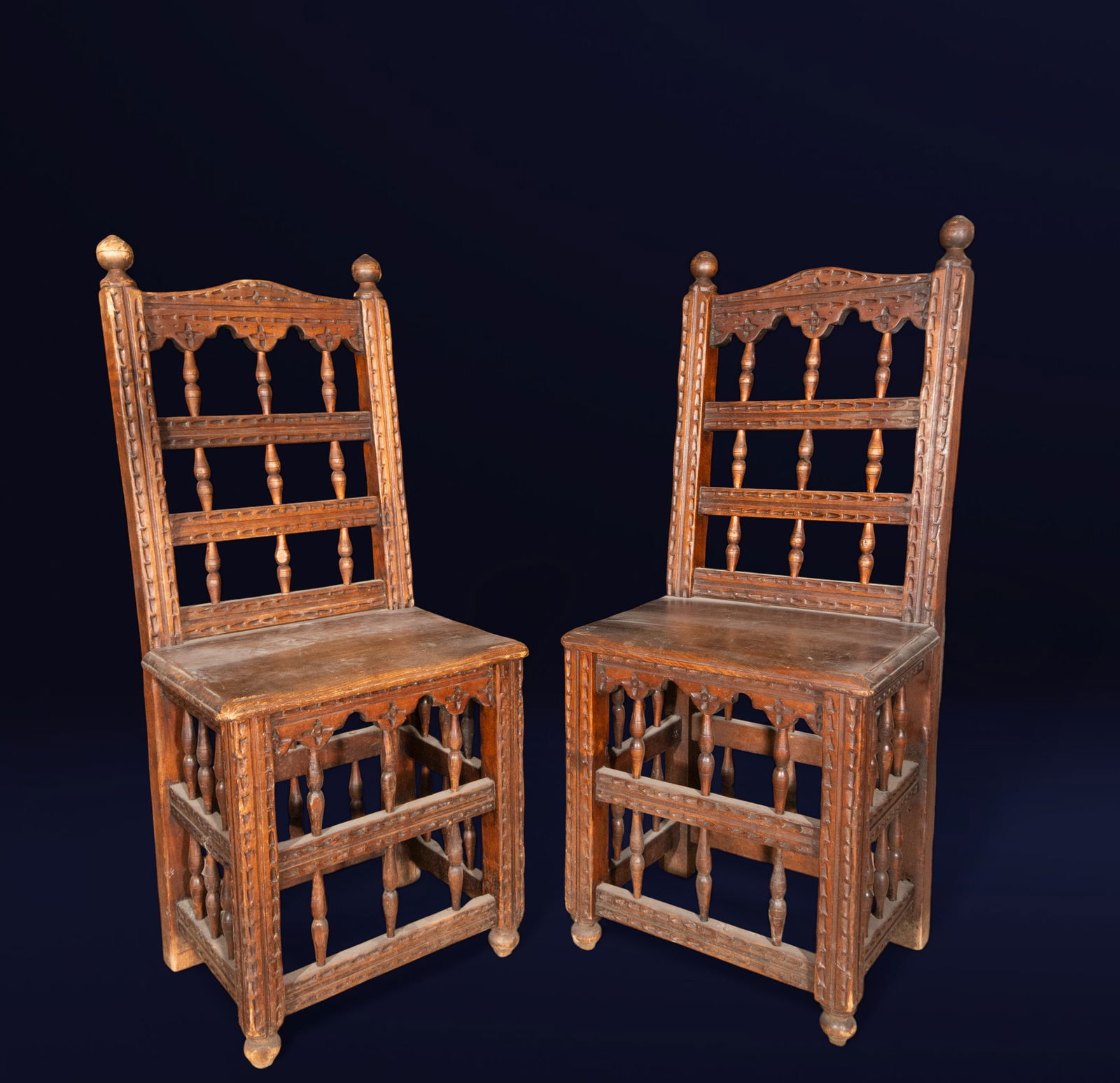 Pair of chairs from Guadalajara, Spanish school, 18th century: Carved wood. Dimensions: 96 x 40 x 32 cm. Pair of chairs from Guadalajara with high backs, turned spindles, and geometric linear carving on the uprights and crossbars. The straight structure and incis