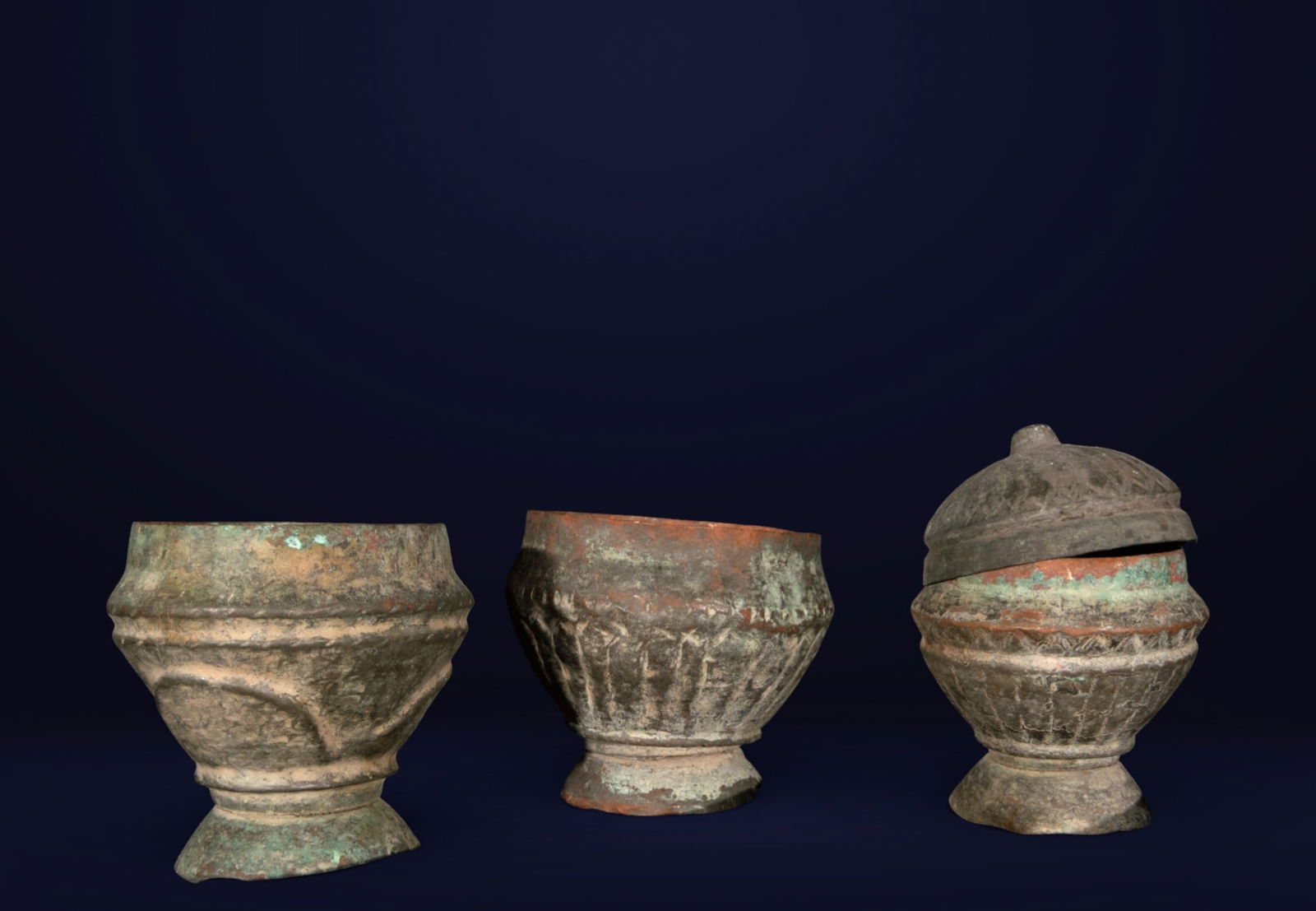Set of three antique cups, Hispano-Moorish School, 16th century or earlier: Cast and worked metal. Dimensions: 11 × 12 × 12 cm / 11 × 12 × 12 cm / 16 × 10 × 10 cm. Set of three small cups or utilitarian vessels with flared profiles and prominent bases. The surfaces show