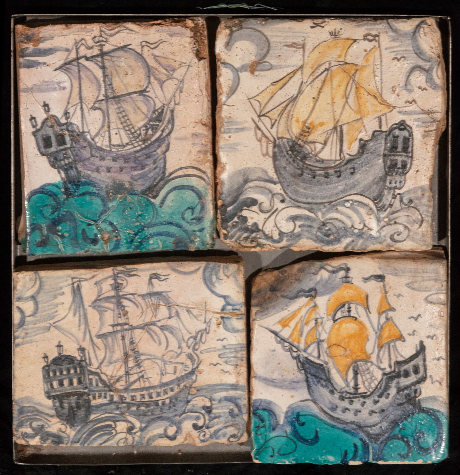 Set of four tiles with ships, Portuguese or Spanish School, 19th Century: Glazed and painted ceramic. Set dimensions: 44 × 39 × 14 cm. Set of four tiles decorated with sailboats navigating through waves, rendered in a palette of blues, greens, and yellows. The composition
