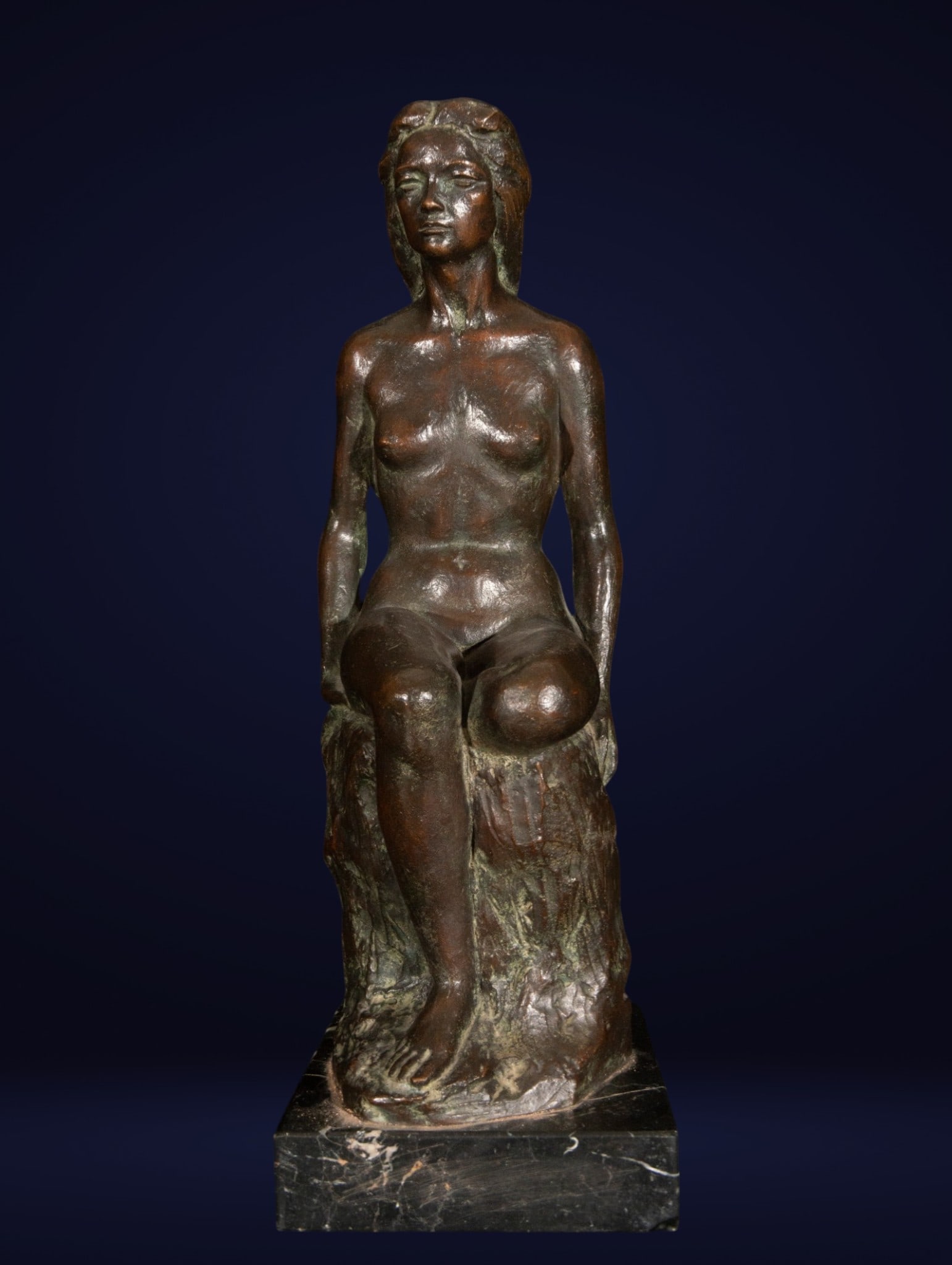 Female nude, Signed Santiago de Santiago Hernández, Spanish School, 20th Century: Bronze sculpture with a dark patina. Measures 28 x 55 x 17 cm. Nude female figure seated on a tree trunk, depicted with a serene and contemplative attitude, her head slightly raised and her anatomy st