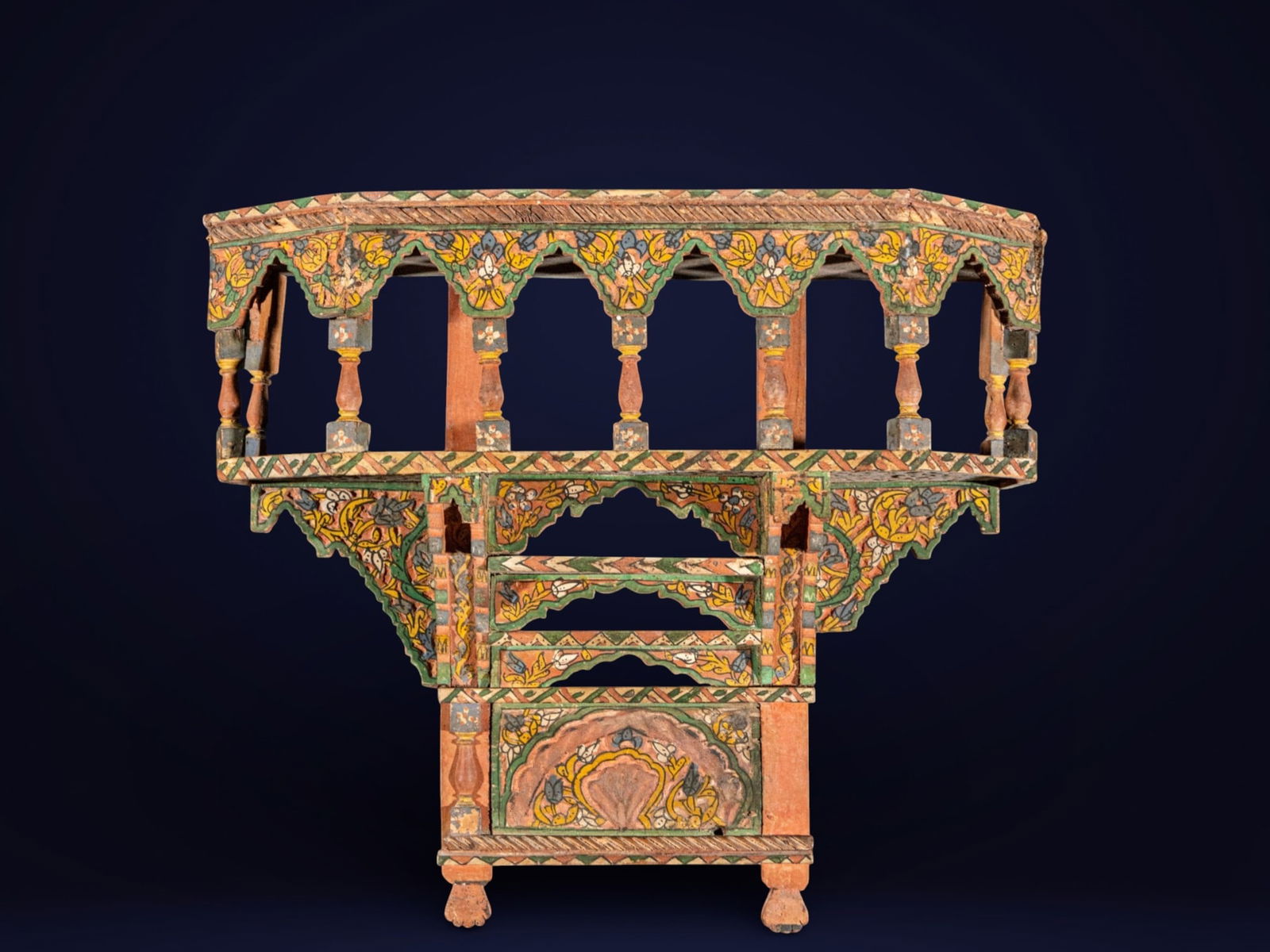 Indian corbel in polychrome wood, Orientalizing School, 18th - 19th century: Carved and polychromed wood. Measures 63 x 70 x 20 cm. Wall bracket with an architectural structure, featuring a balustrade at the top, sculpted arches, and rich geometric and floral decoration painte