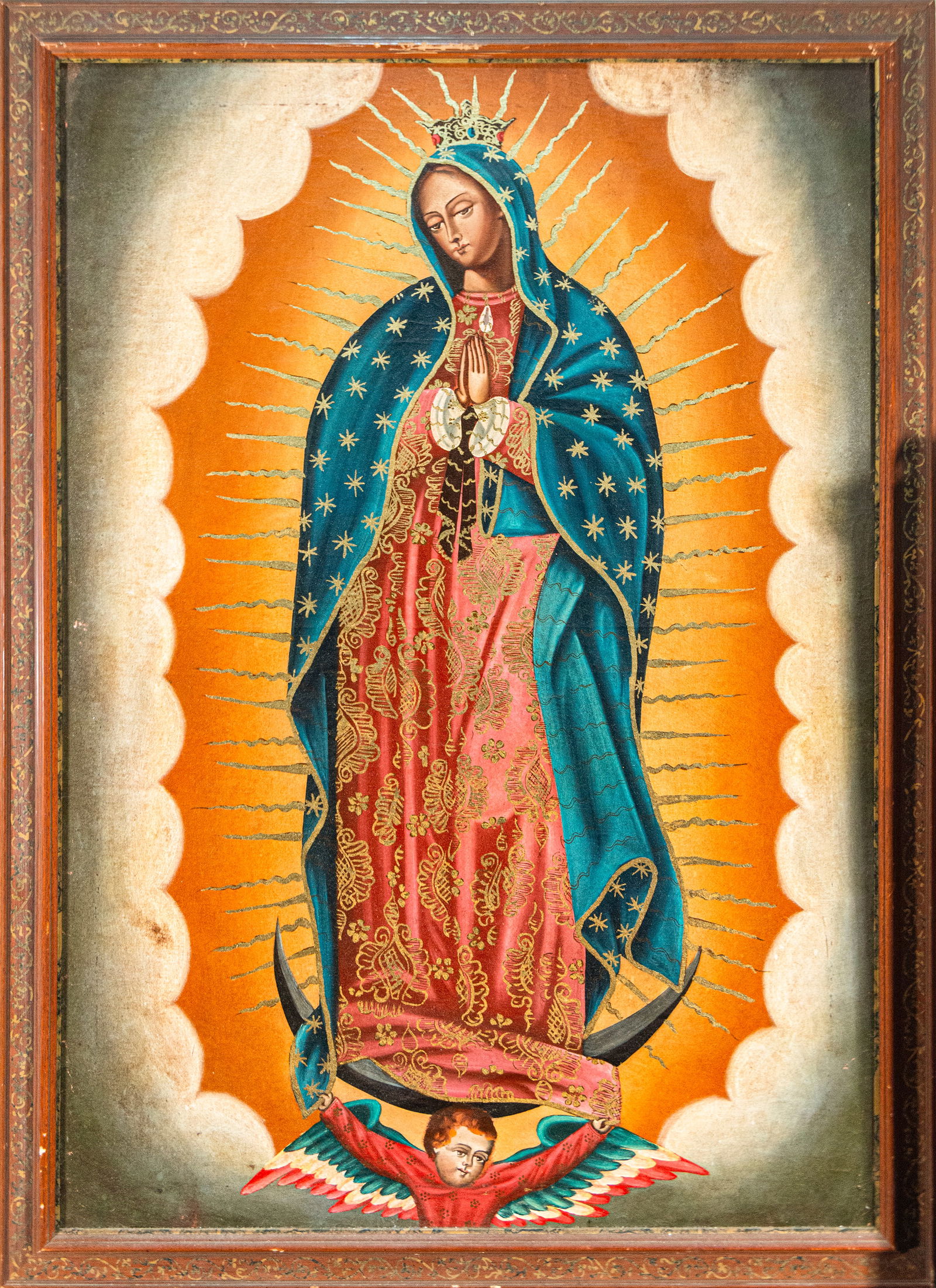 Virgin of Guadalupe, Mexican school, 20th century: Oil on canvas. Dimensions 109 x 79 / 120 x 98 cm. Image of the Virgin of Guadalupe according to traditional iconography, standing on the moon held by an angel, with hands clasped, wearing a starry blu