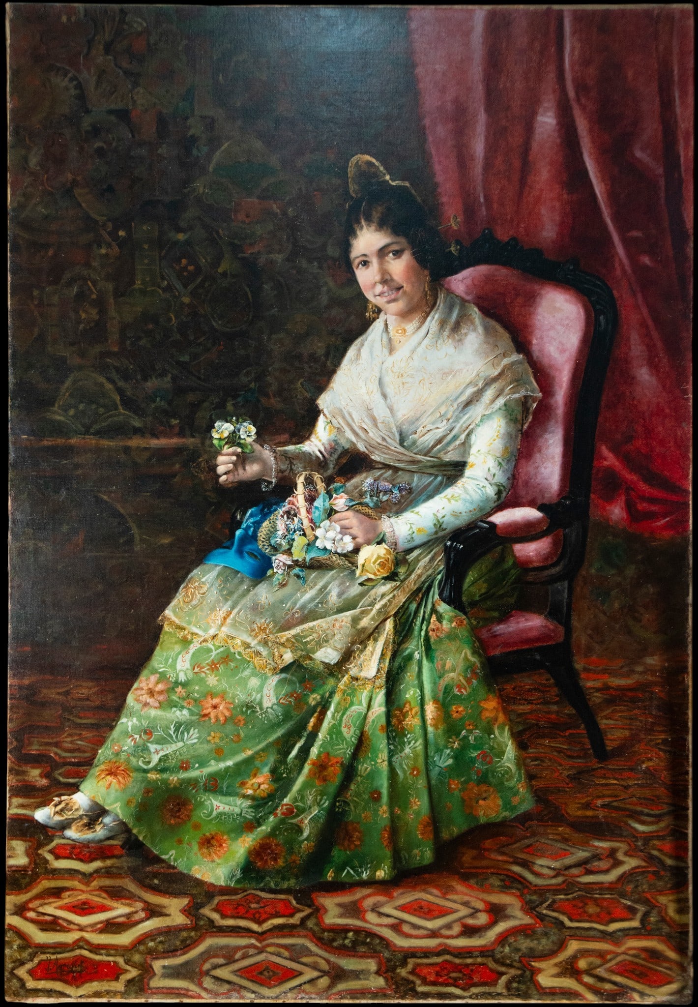 Valencian woman seated with flowers, Signed J. Agrasot, Spanish school, 19th century: Oil on canvas. Dimensions 161 x 110 cm. Portrait of a Valencian lady seated in an upholstered armchair, dressed in rich regional attire and holding a small bouquet while a basket of flowers rests on h
