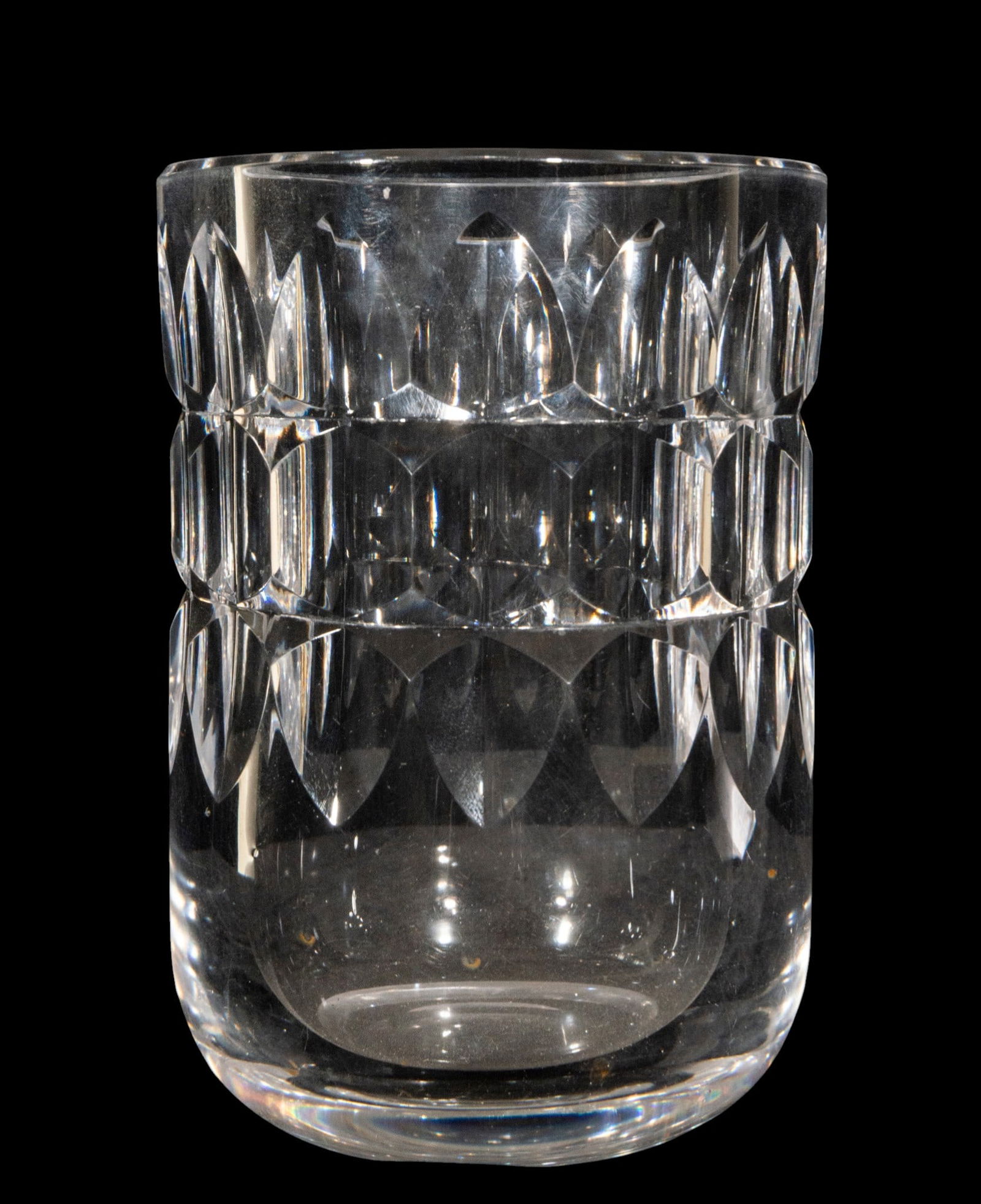 Cut crystal vase, attributed to Charles Graffart, Belgium, circa 1950, 20th century: Cut crystal. Measures 17 x 12 x 12 cm. This cylindrical vase, with its understated proportions, is crafted from a thick, colorless crystal worked with a succession of oval facets and geometric cuts ar