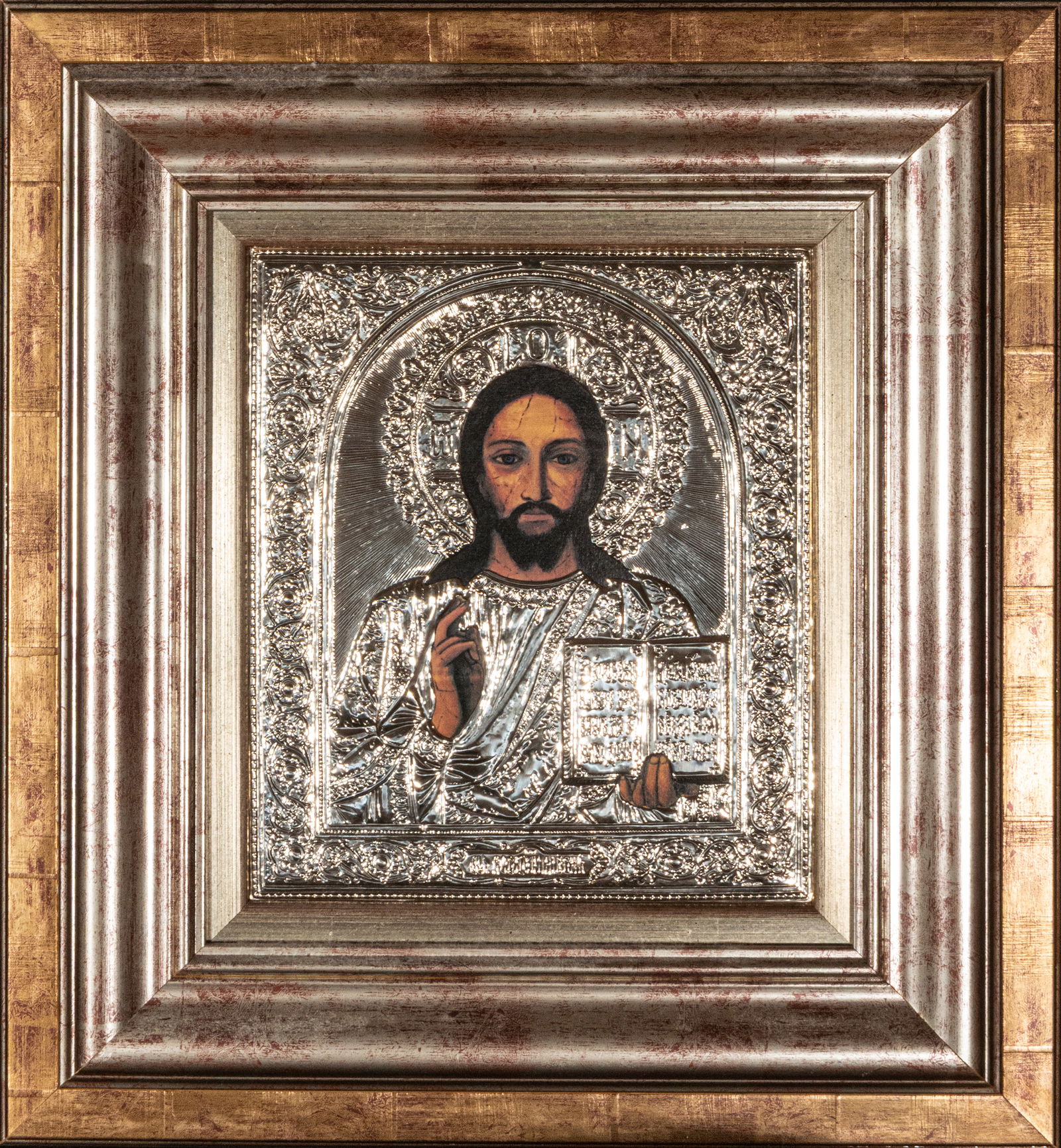 Icon of the Pantocrator, Orthodox School, 20th Century, with seal: Repoussé silver on a wooden support. Measures 46 x 43 cm. Icon of Christ Pantocrator in the Orthodox tradition, depicted frontally with Christ blessing with his right hand while holding an open book,